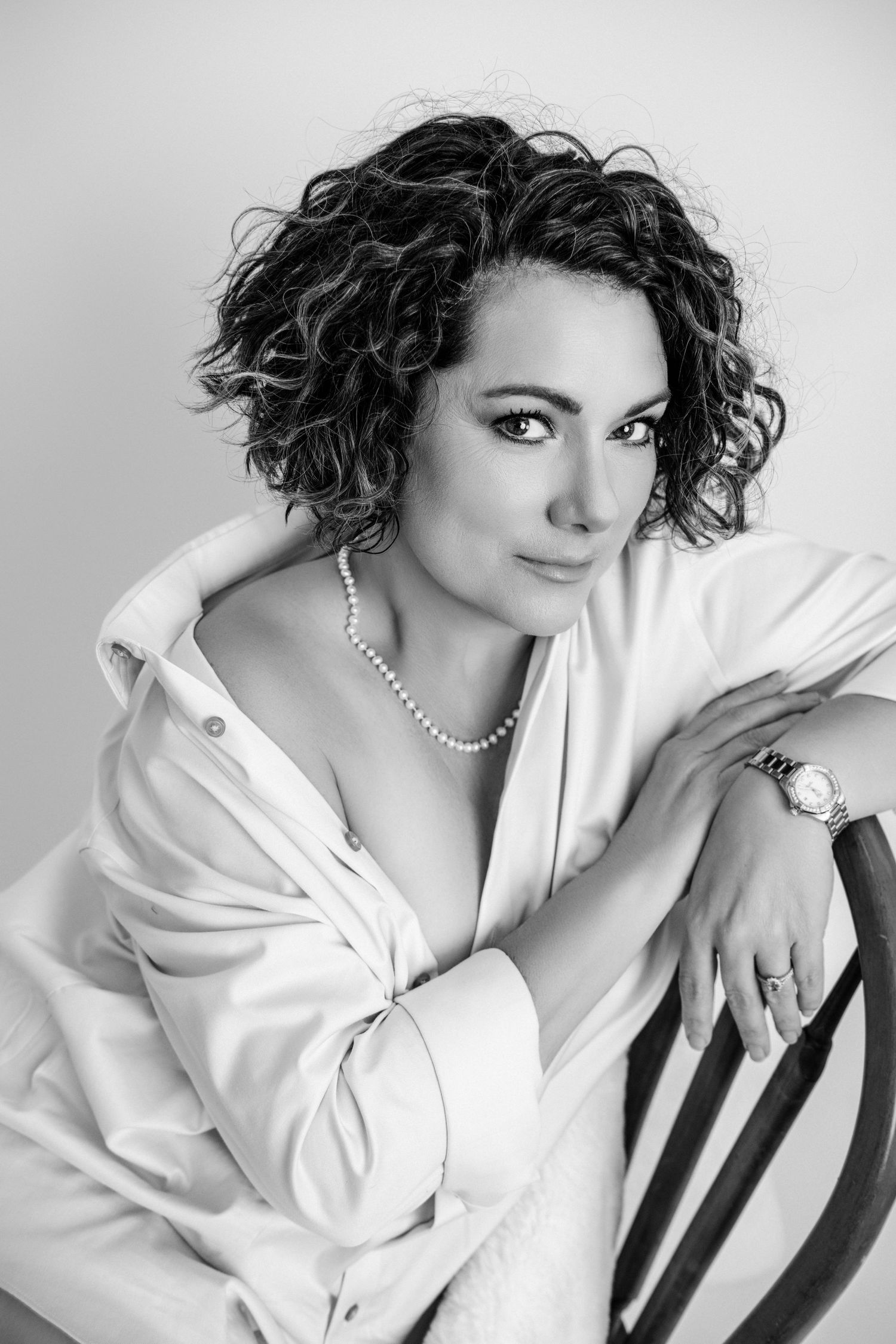 Professional studio portraits featuring white button-down shirt and pearl necklace.