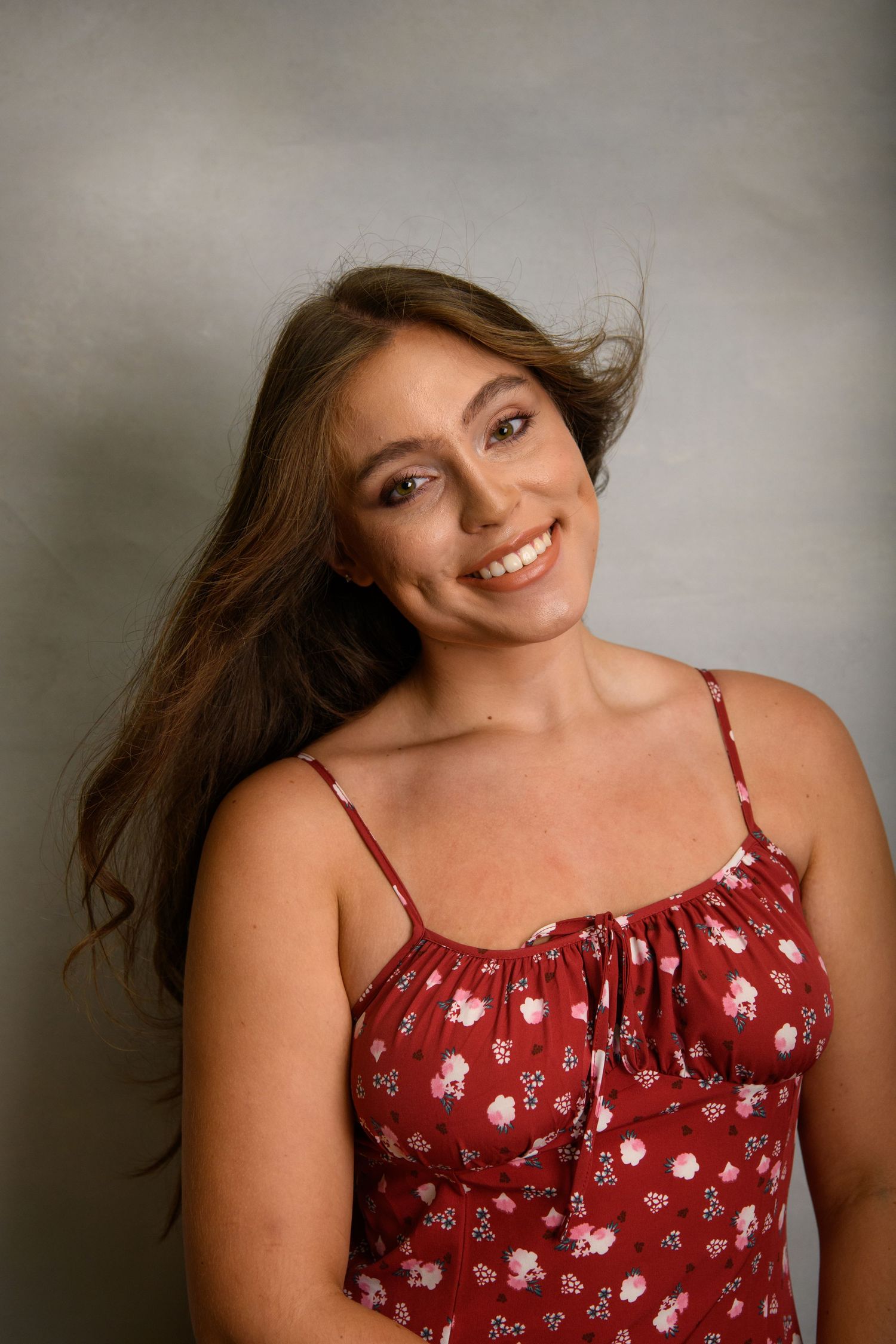 Fashion portraits in a red floral summer dress with natural flowing hair movement.