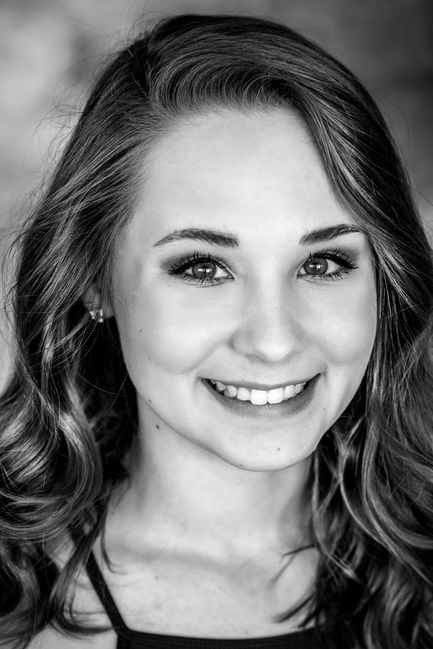 Black and white headshot series showing various expressions and angles.