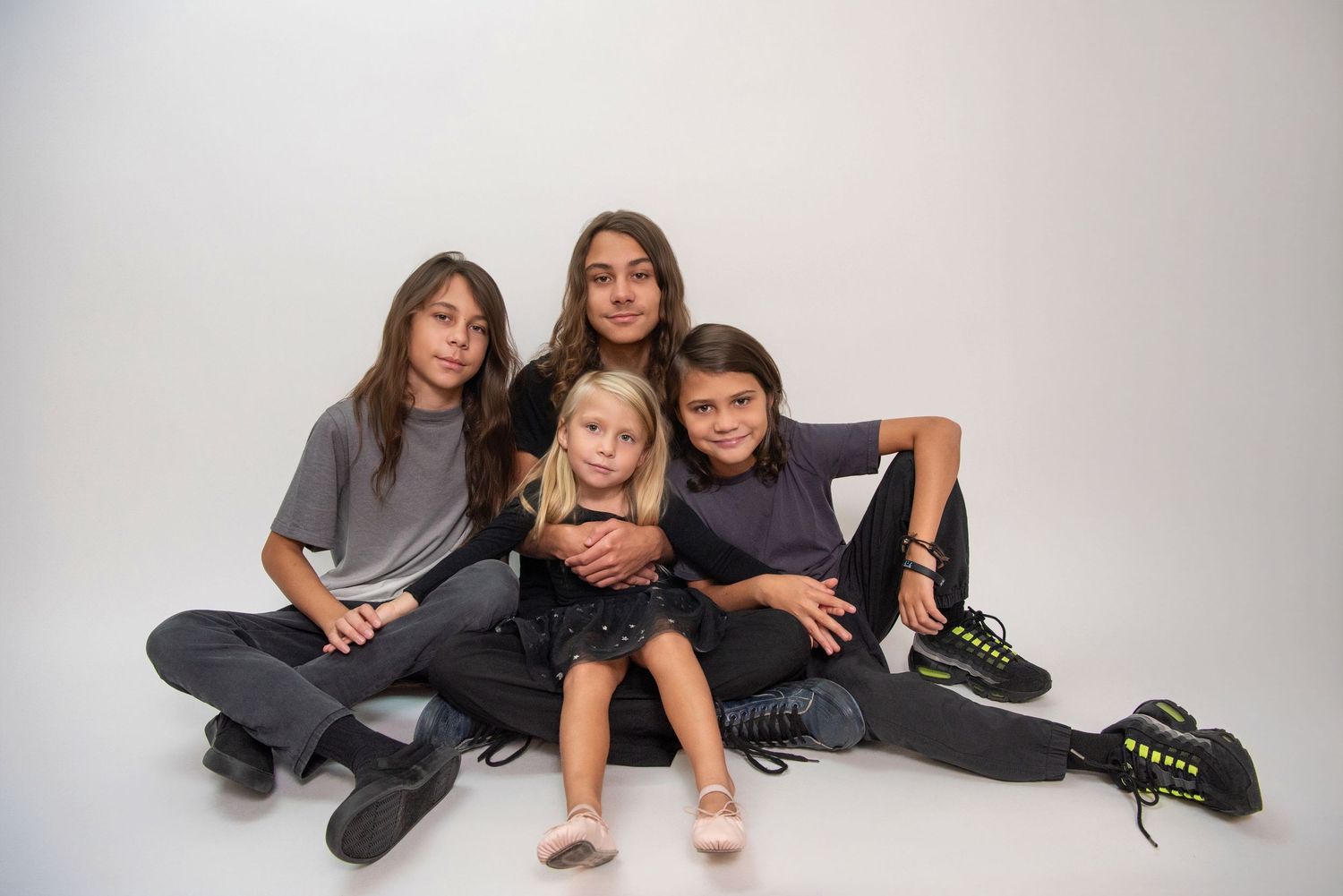 Group portrait showing casual poses against white background.