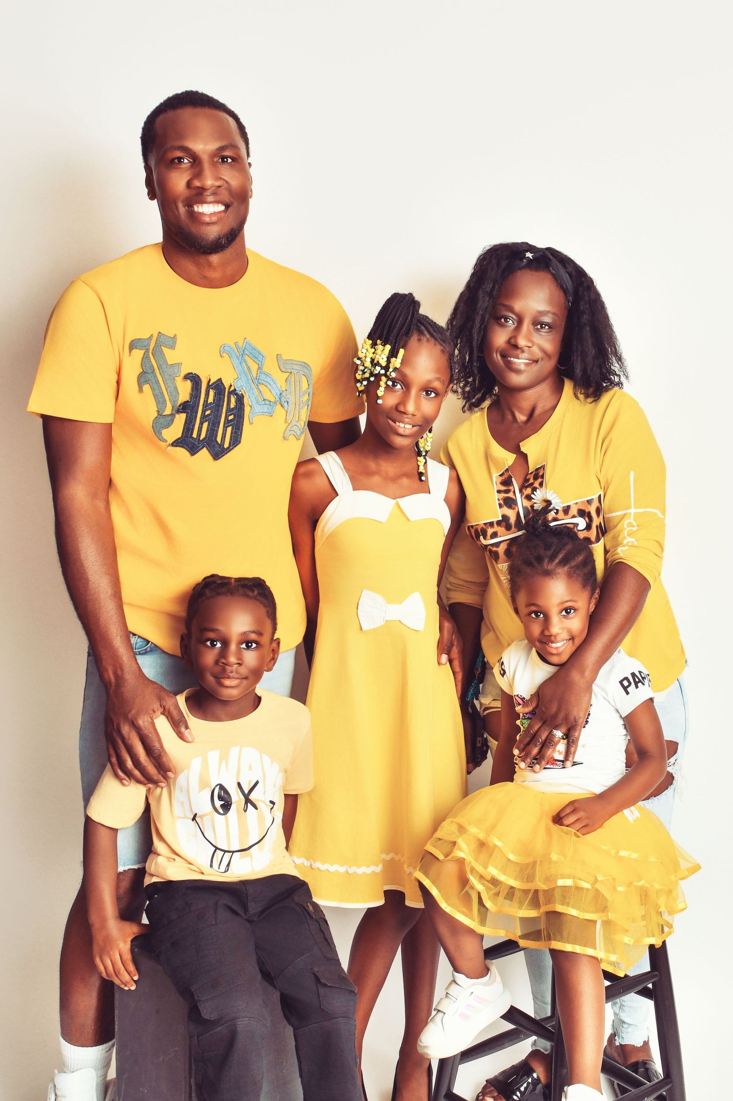 A family wearing coordinated yellow outfits poses together for a portrait.
