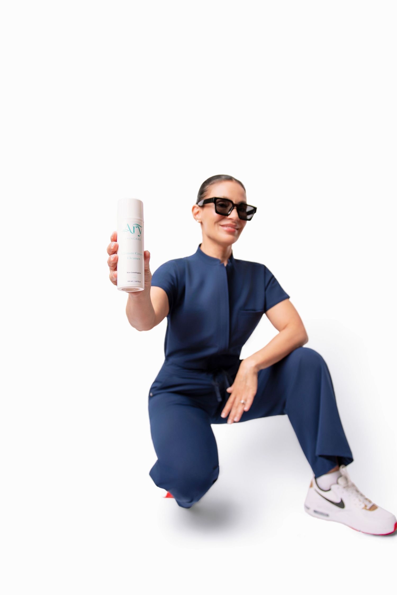 Dynamic product photography poses showing white container with navy outfit.