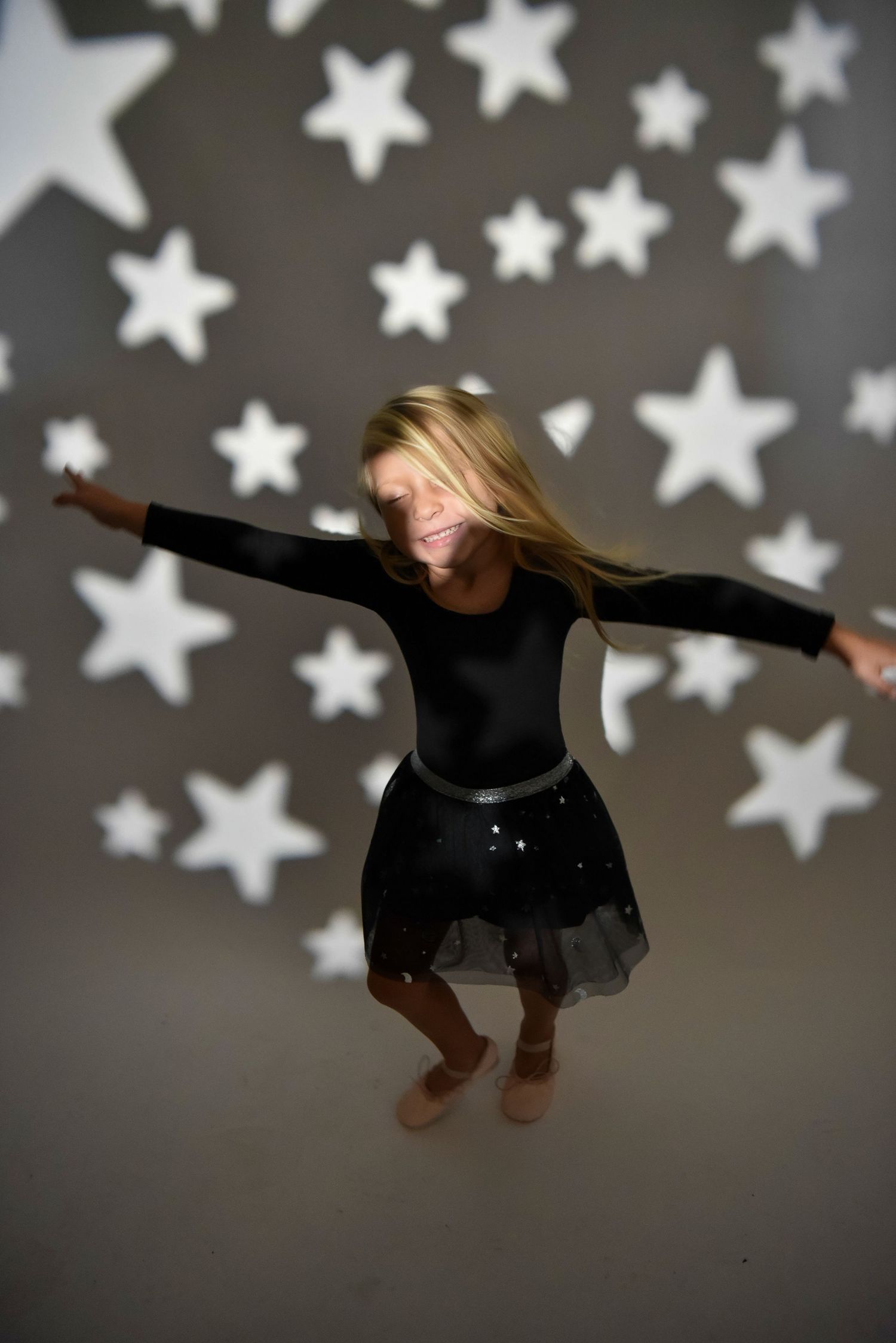 Creative portrait with projected star patterns and dynamic movement.