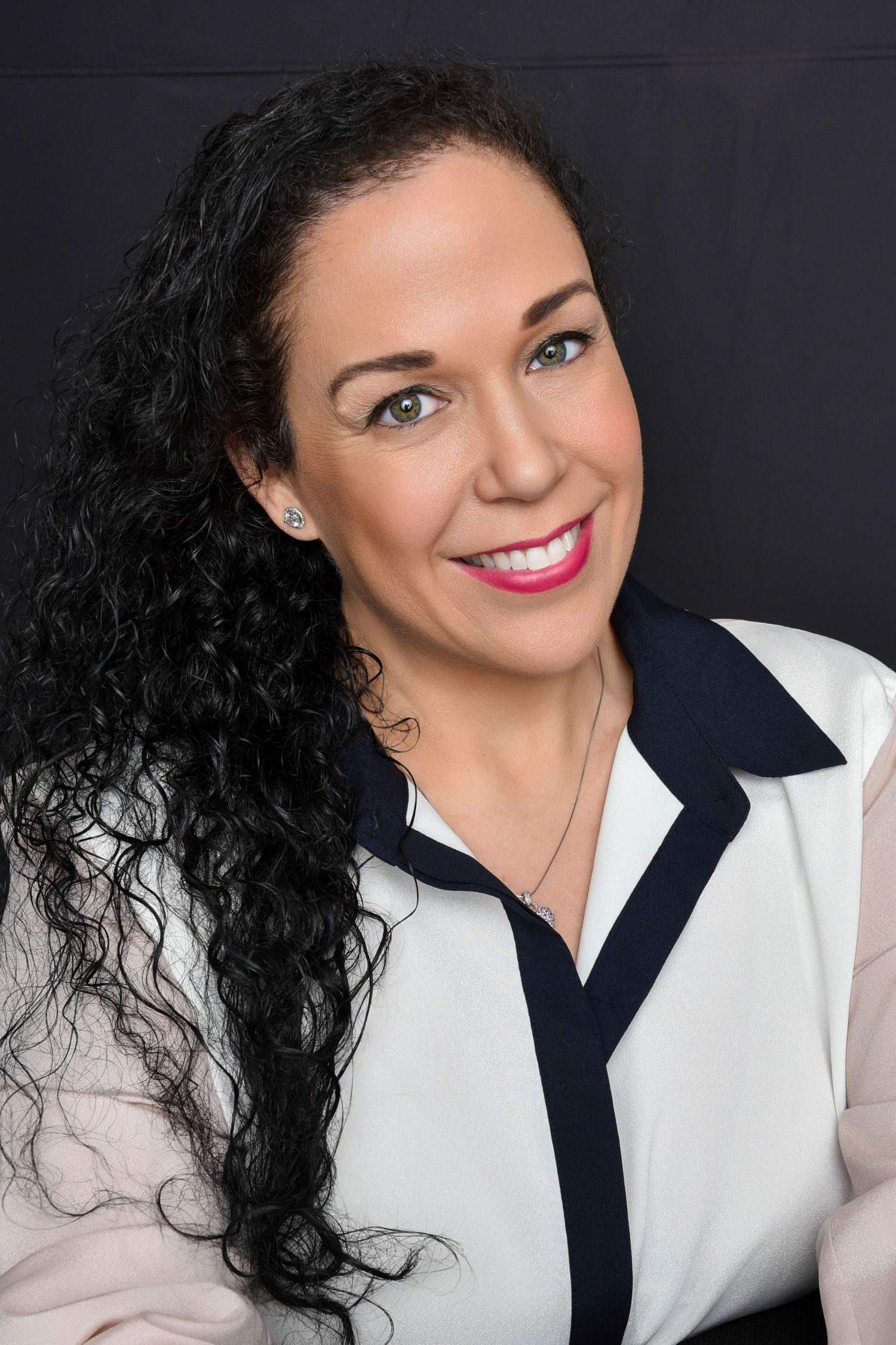 Professional headshot series showing warm smile against dark background wearing white collared top.