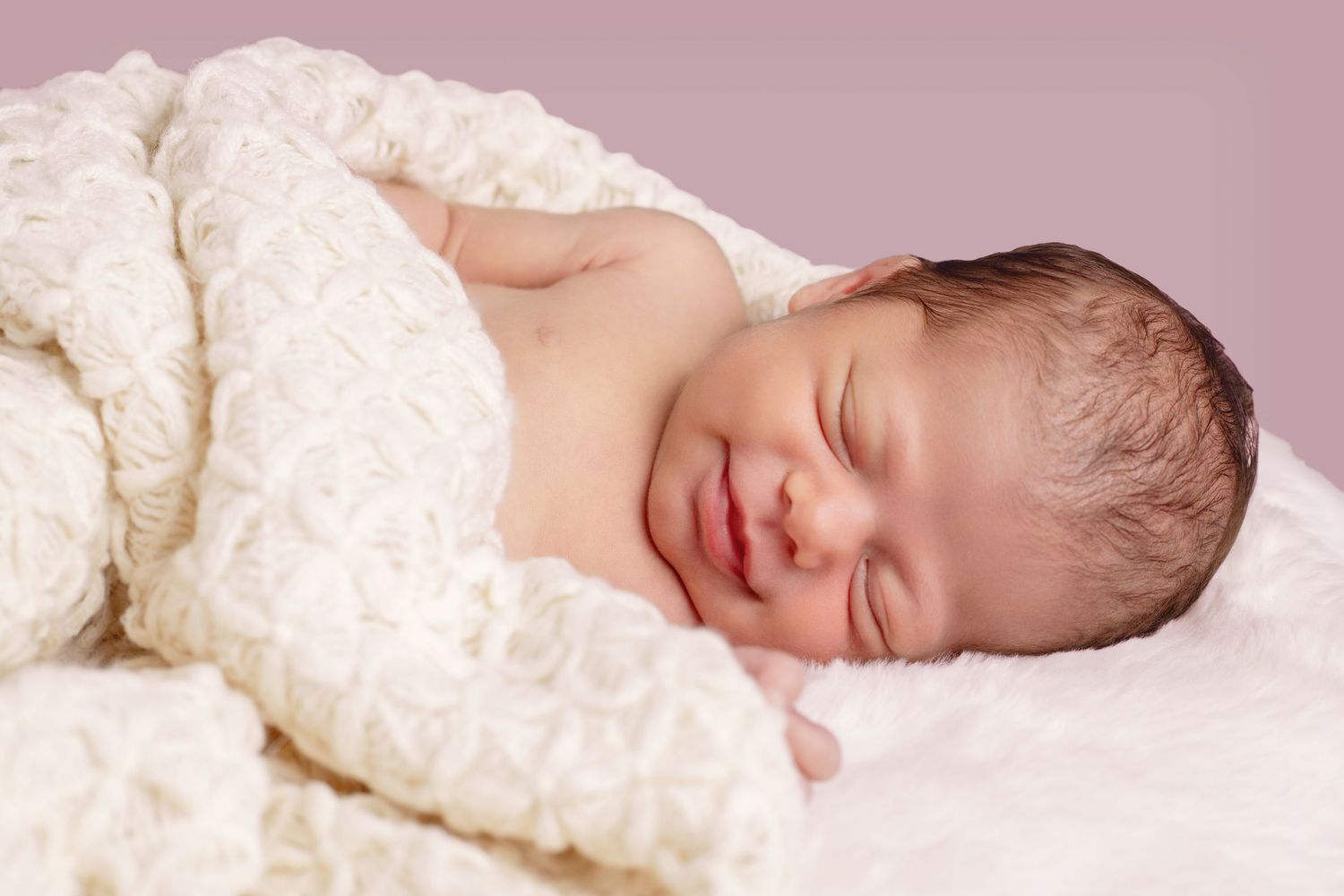 Close-up sequence of sleeping newborn against pink background.