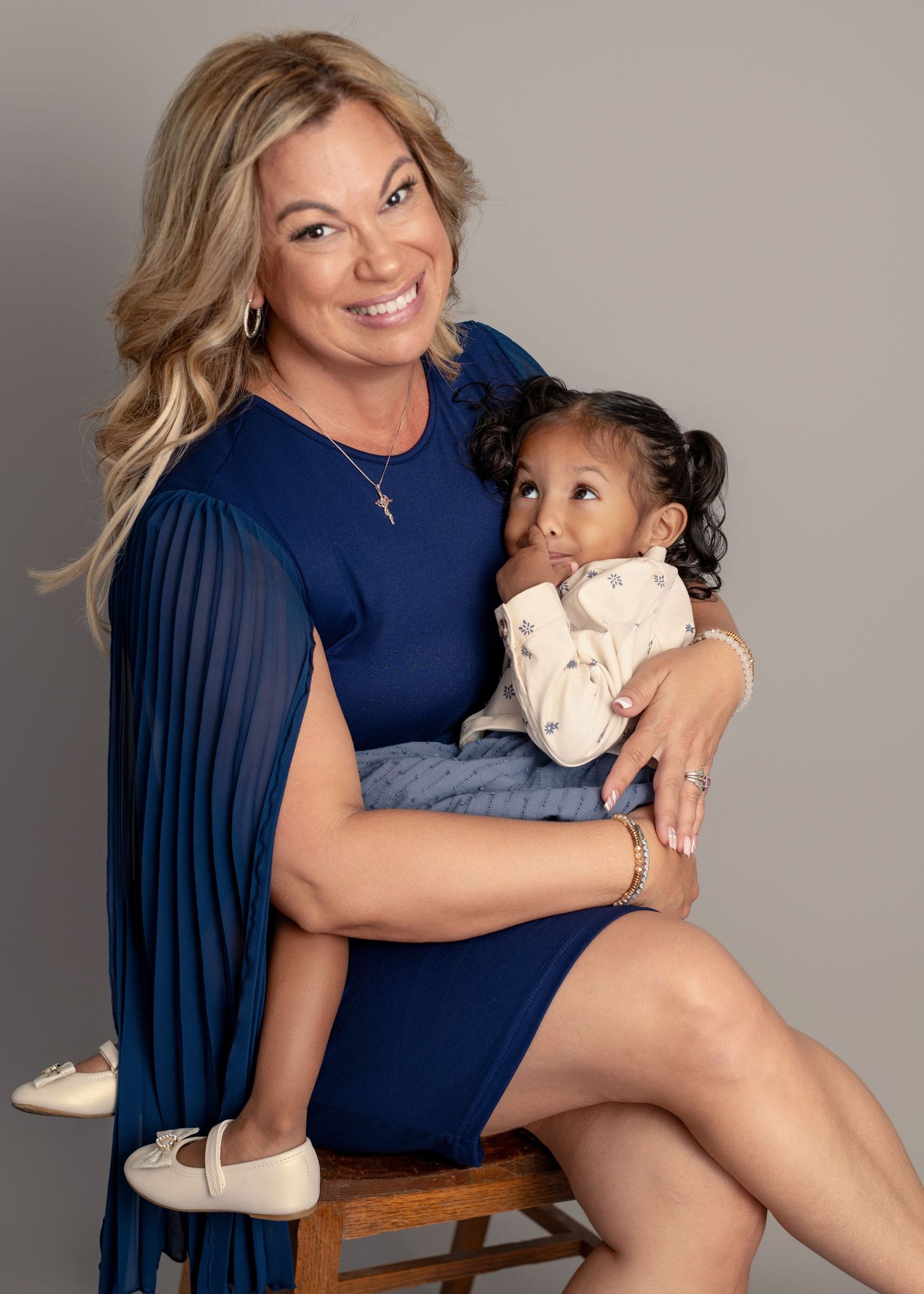 Studio portrait session featuring navy blue dress and intimate poses against grey backdrop.