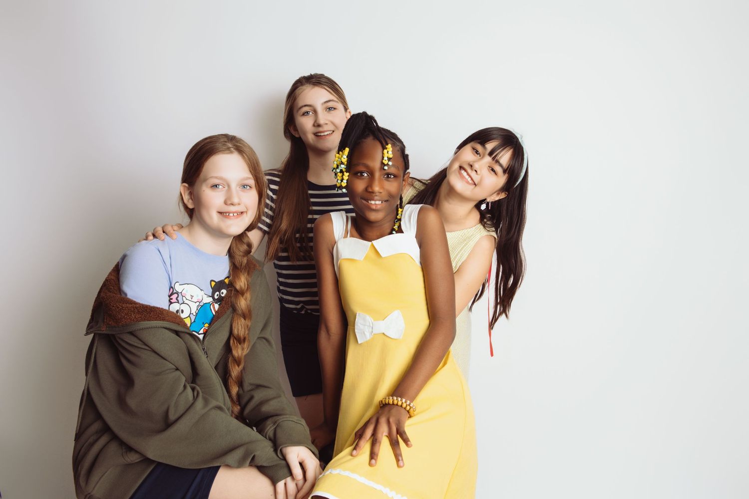 Friends laughing and having fun while posing for a casual photo shoot.