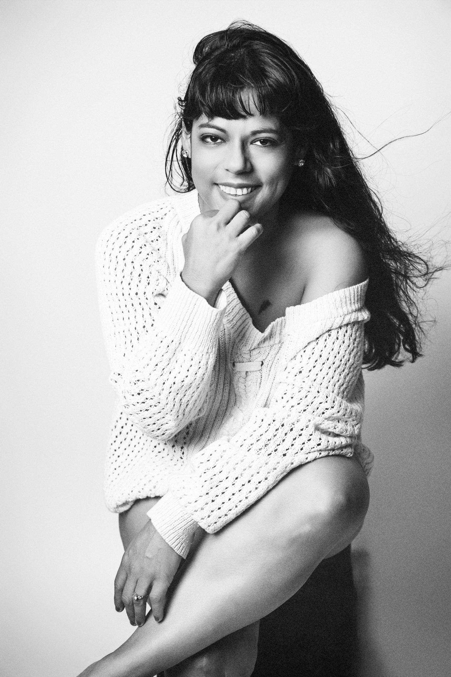 Artistic black and white portraits showing a person in white sweater making expressive poses.