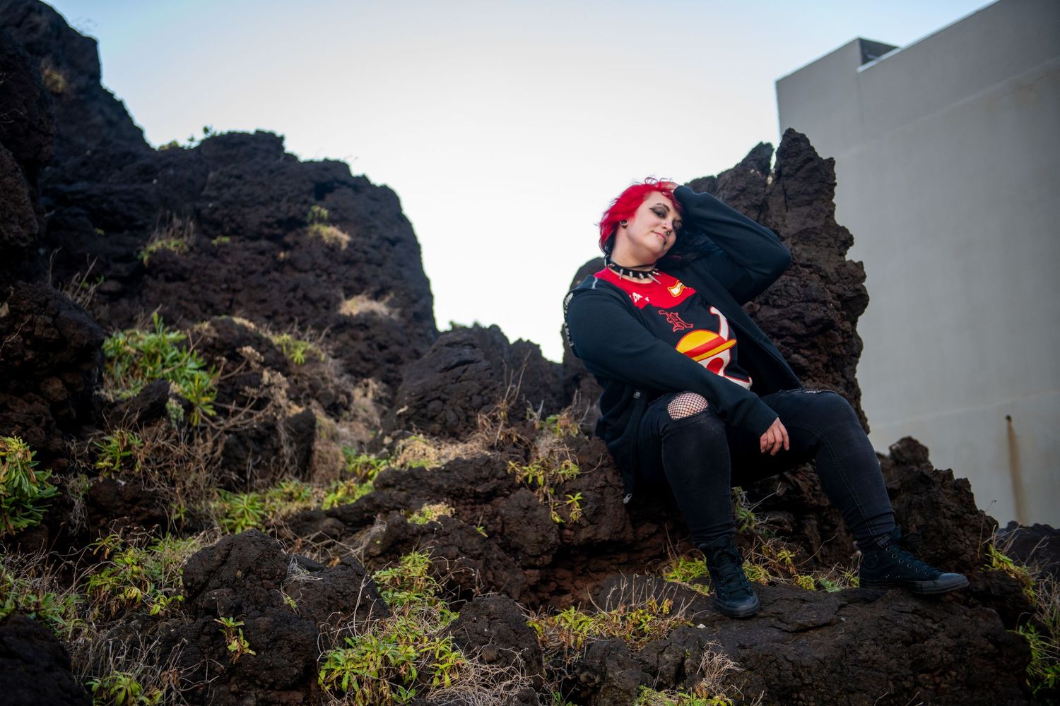 Dramatic coastal cliffs and volcanic rocks frame a romantic photoshoot on a rugged beach.
