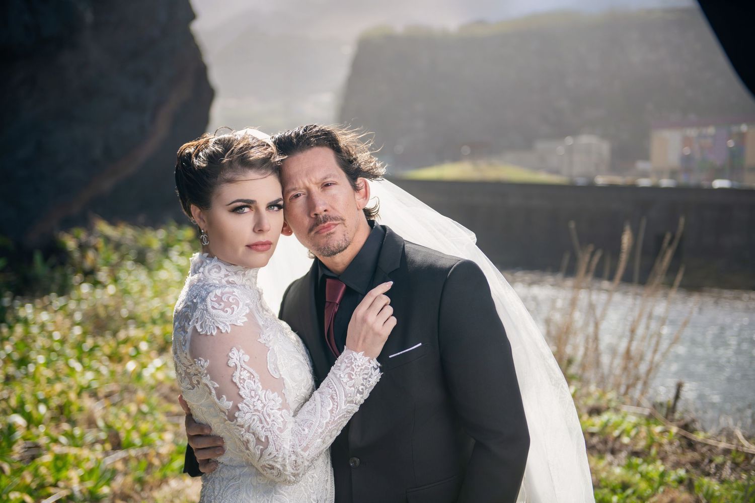 Newlyweds embrace lovingly during outdoor wedding photography session.