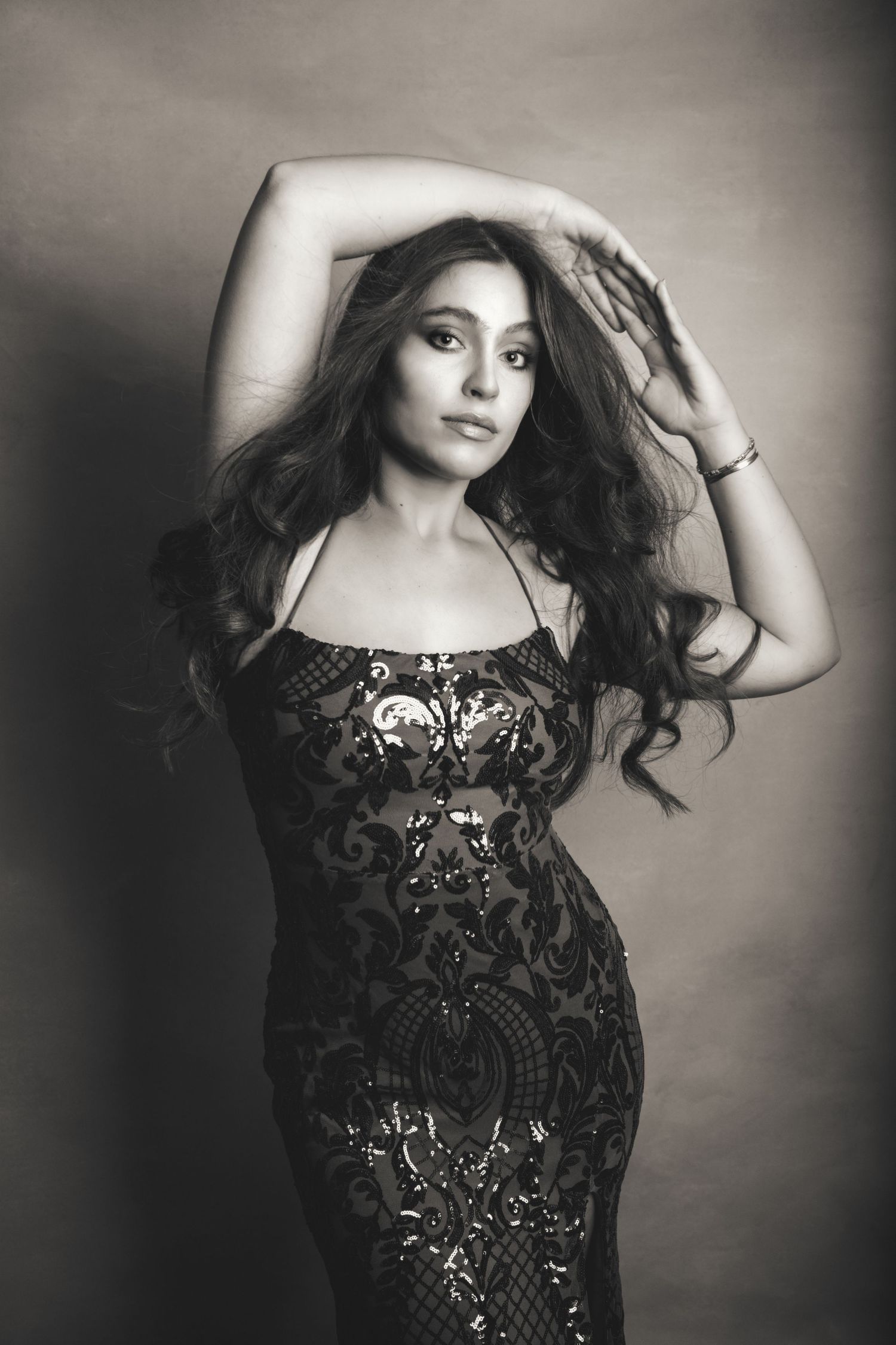 Artistic black and white portrait series featuring flowing dark hair and an embellished black dress.