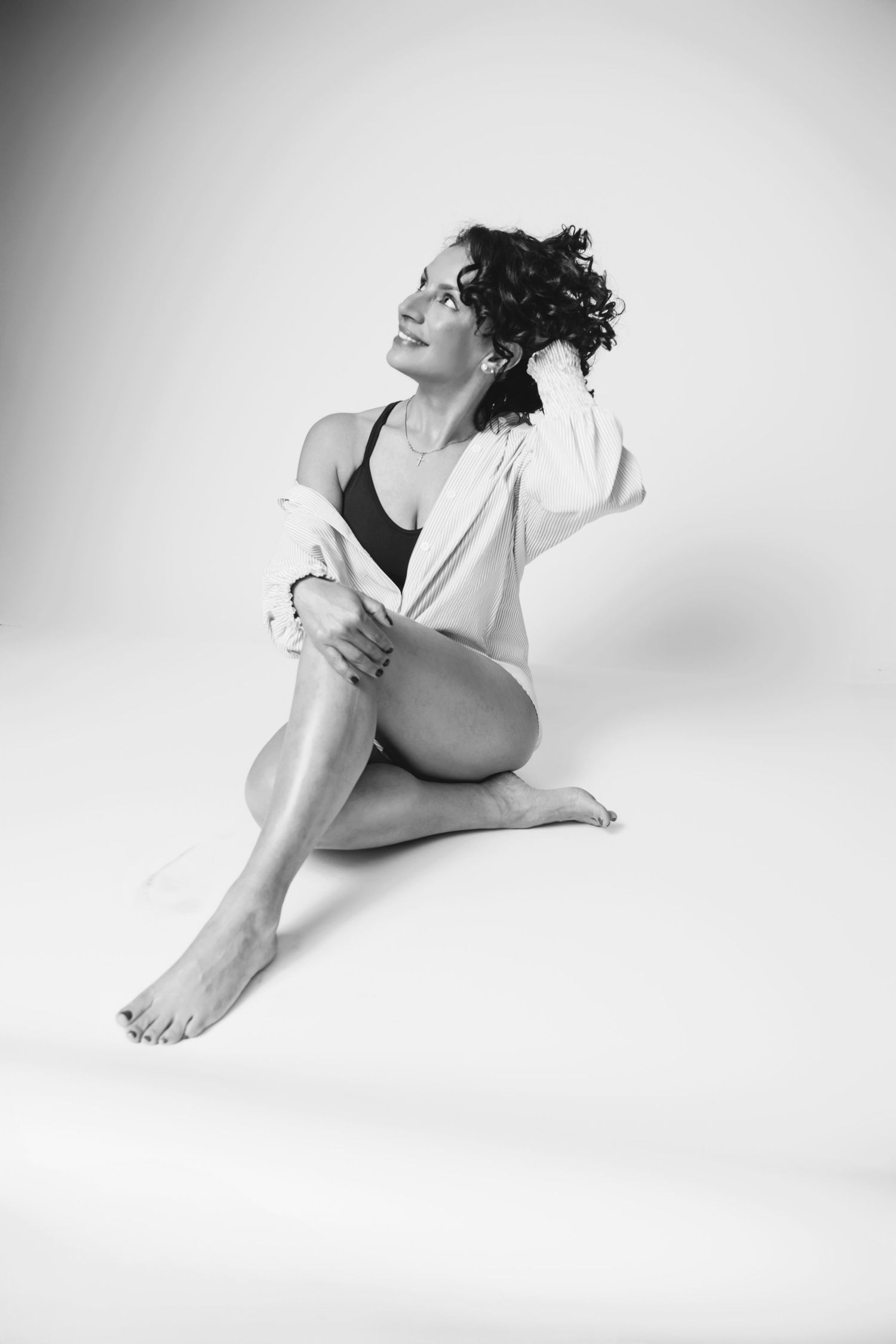 Elegant black and white portrait showing relaxed pose in casual athletic attire.