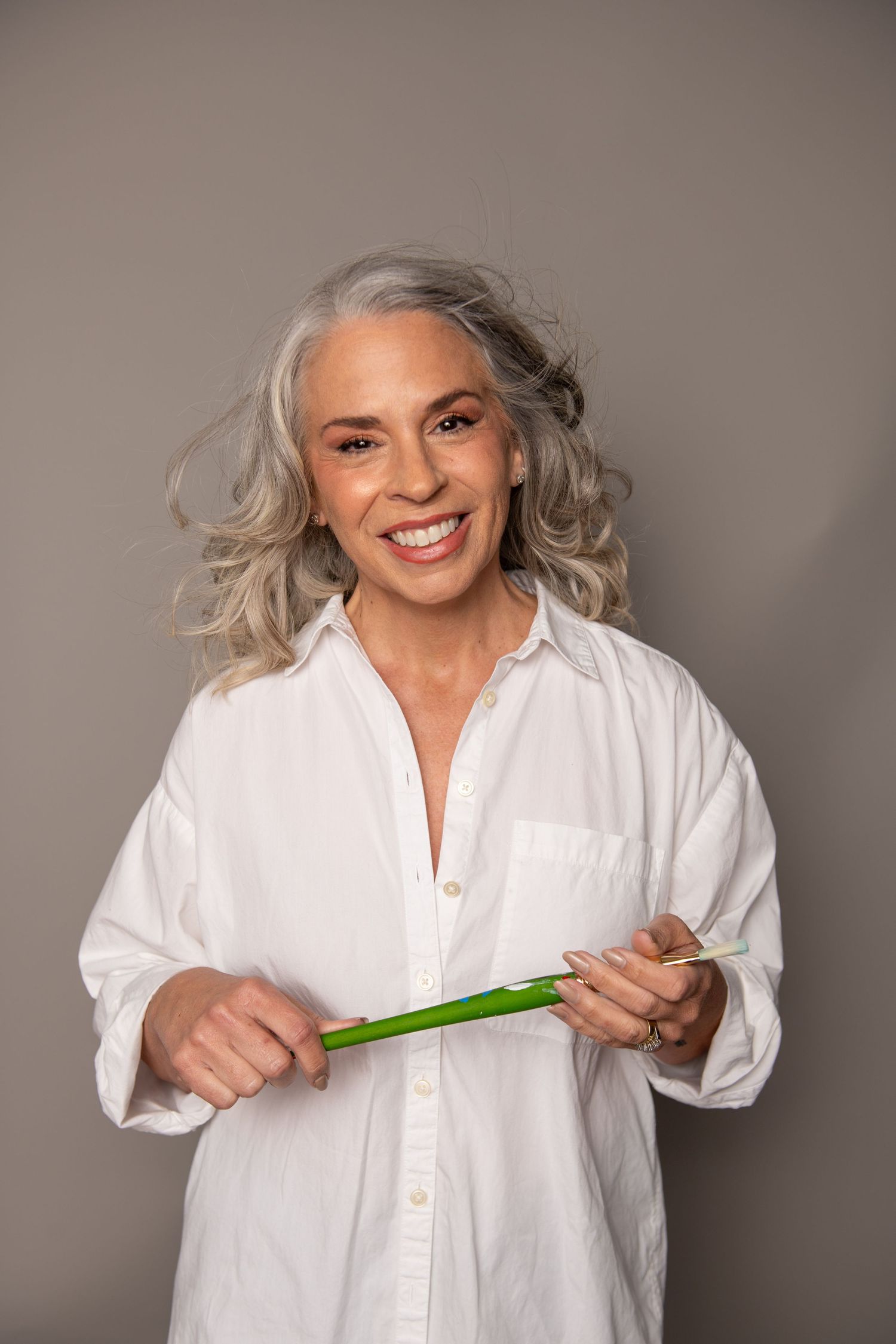 Portrait of Vero beach Bar owner in white button-down shirt holding a green paintbrush.