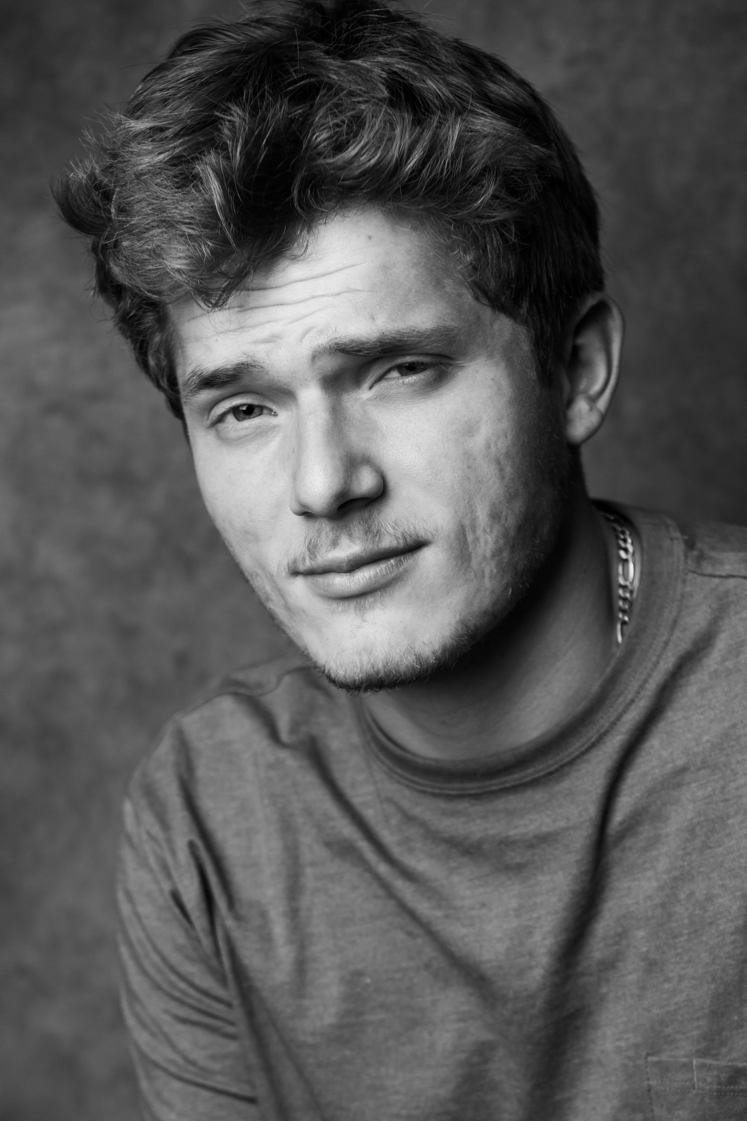 Portrait series showing person in gray shirt with tousled hair against dark background.