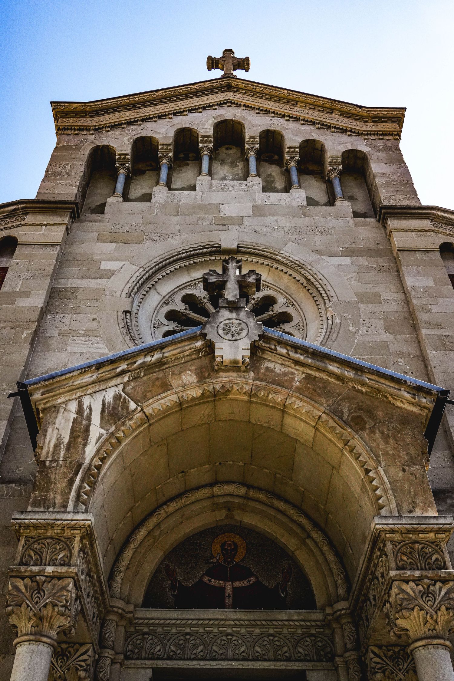 Stone church facade with ornate arched entrance and decorative architectural details.
