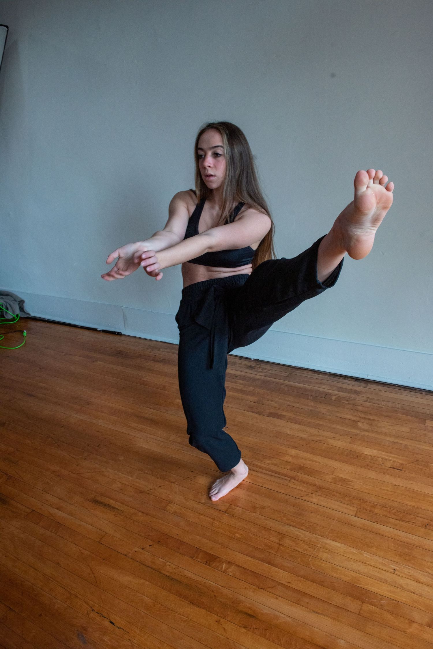 Dynamic dance sequence showing leg extensions and movements on a wooden floor.