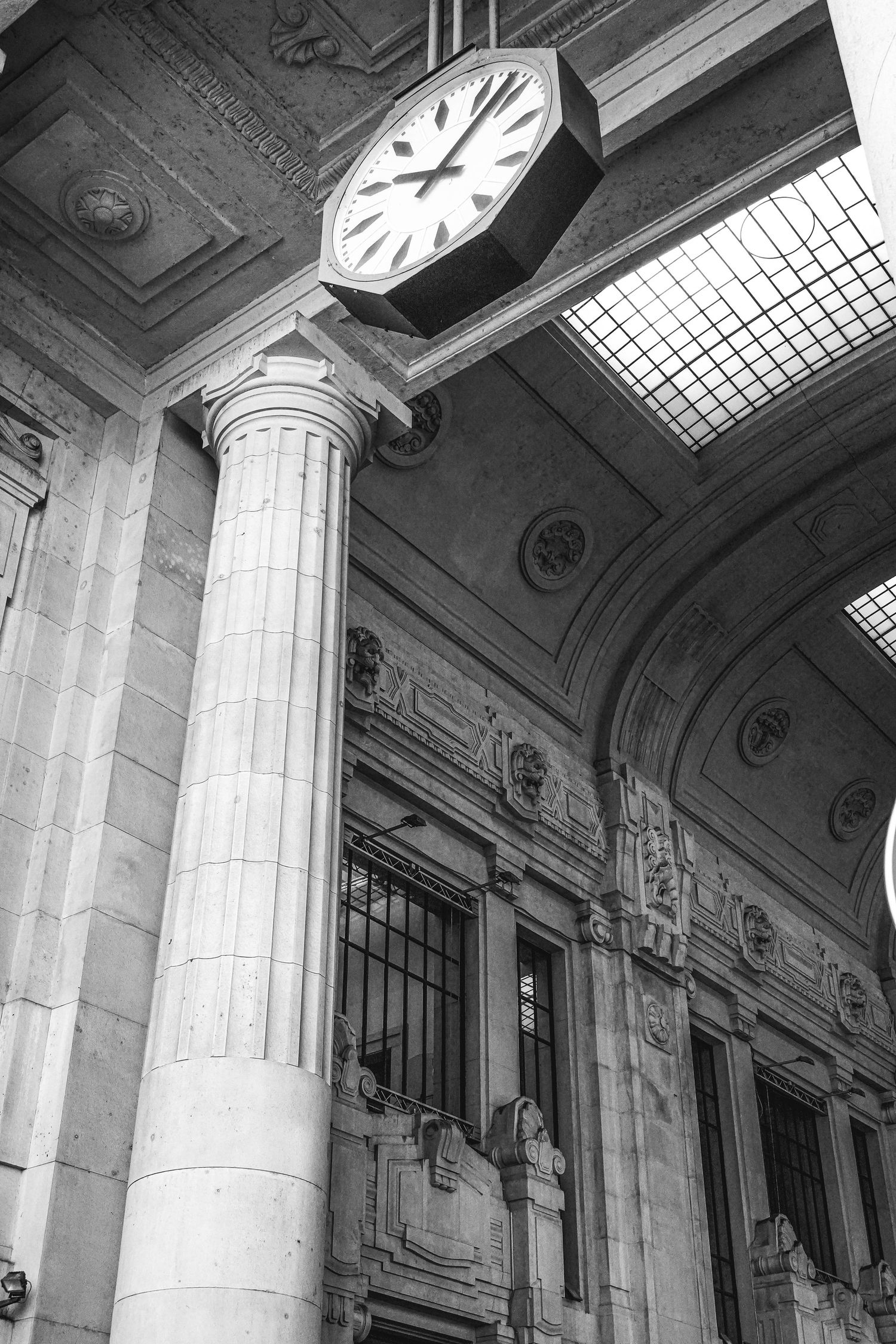 Interior view of classical columns and clock details in a historic building.
