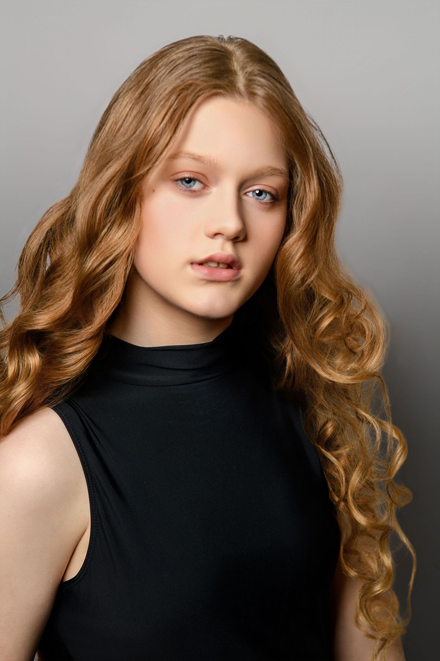 Portrait series showing curly strawberry blonde hair and black sleeveless top against neutral background.