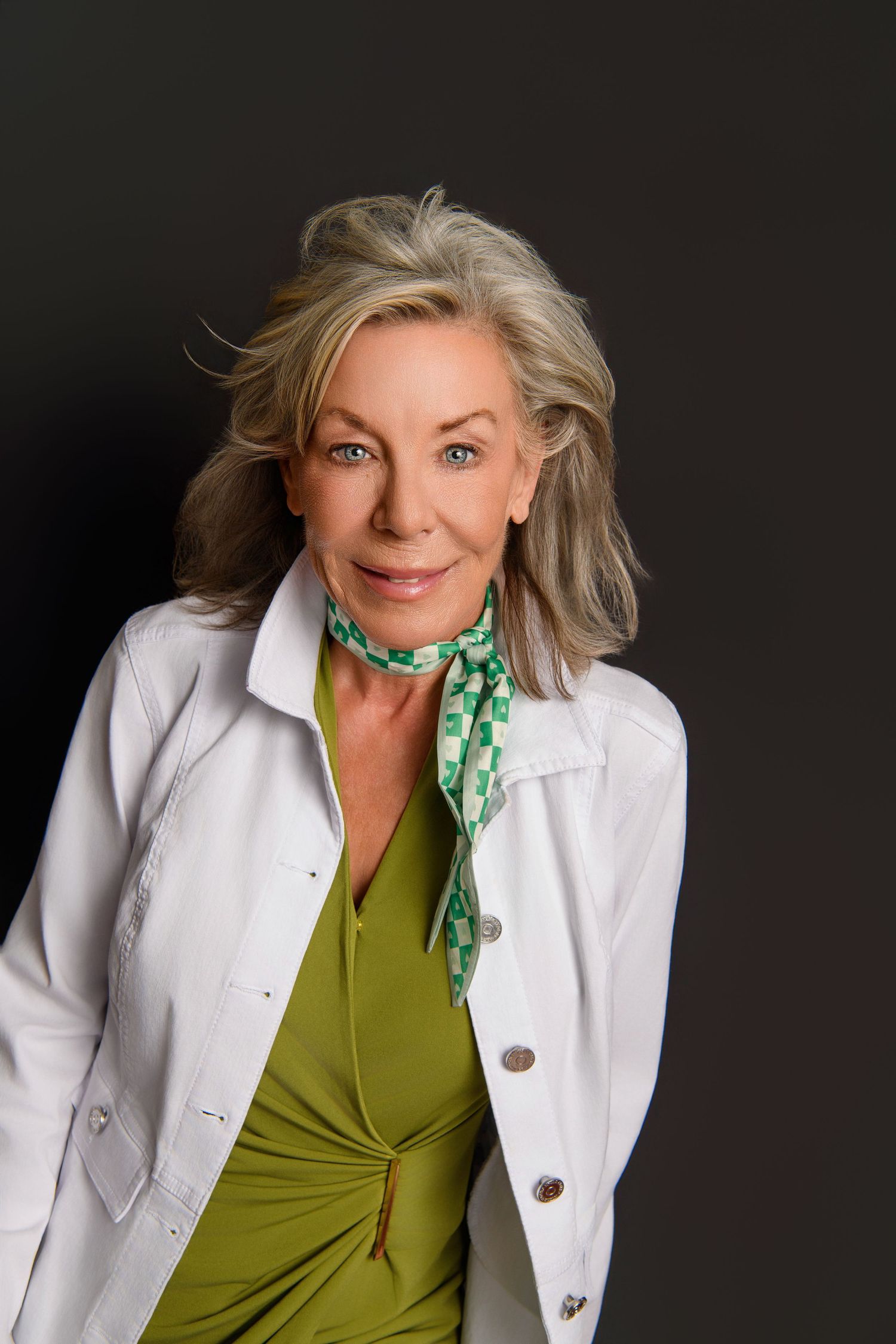 Professional portrait series showing a white blazer and green top with a patterned scarf against dark background.
