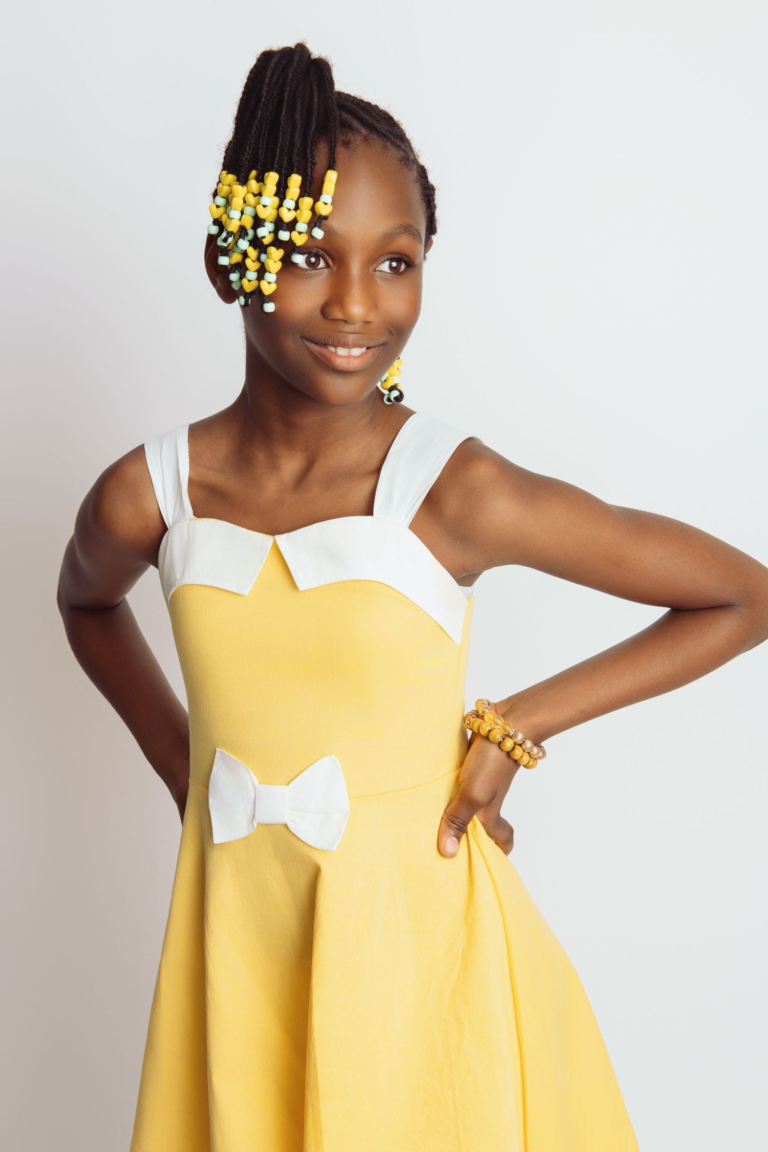 A yellow dress with white bow detail shown in multiple close-up shots.