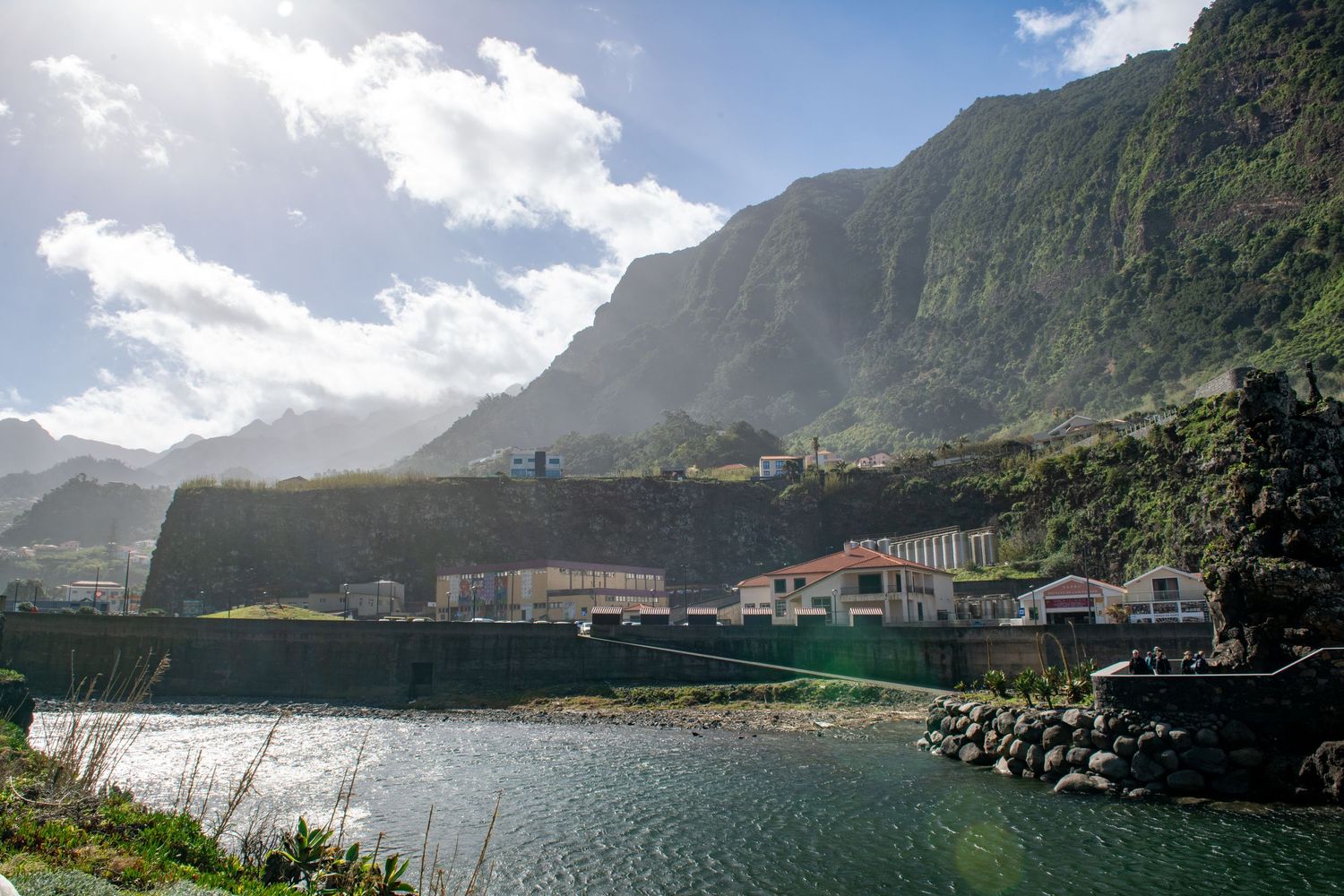 Dramatic coastal landscape with steep cliffs and mountains overlooking a serene bay in multiple views.