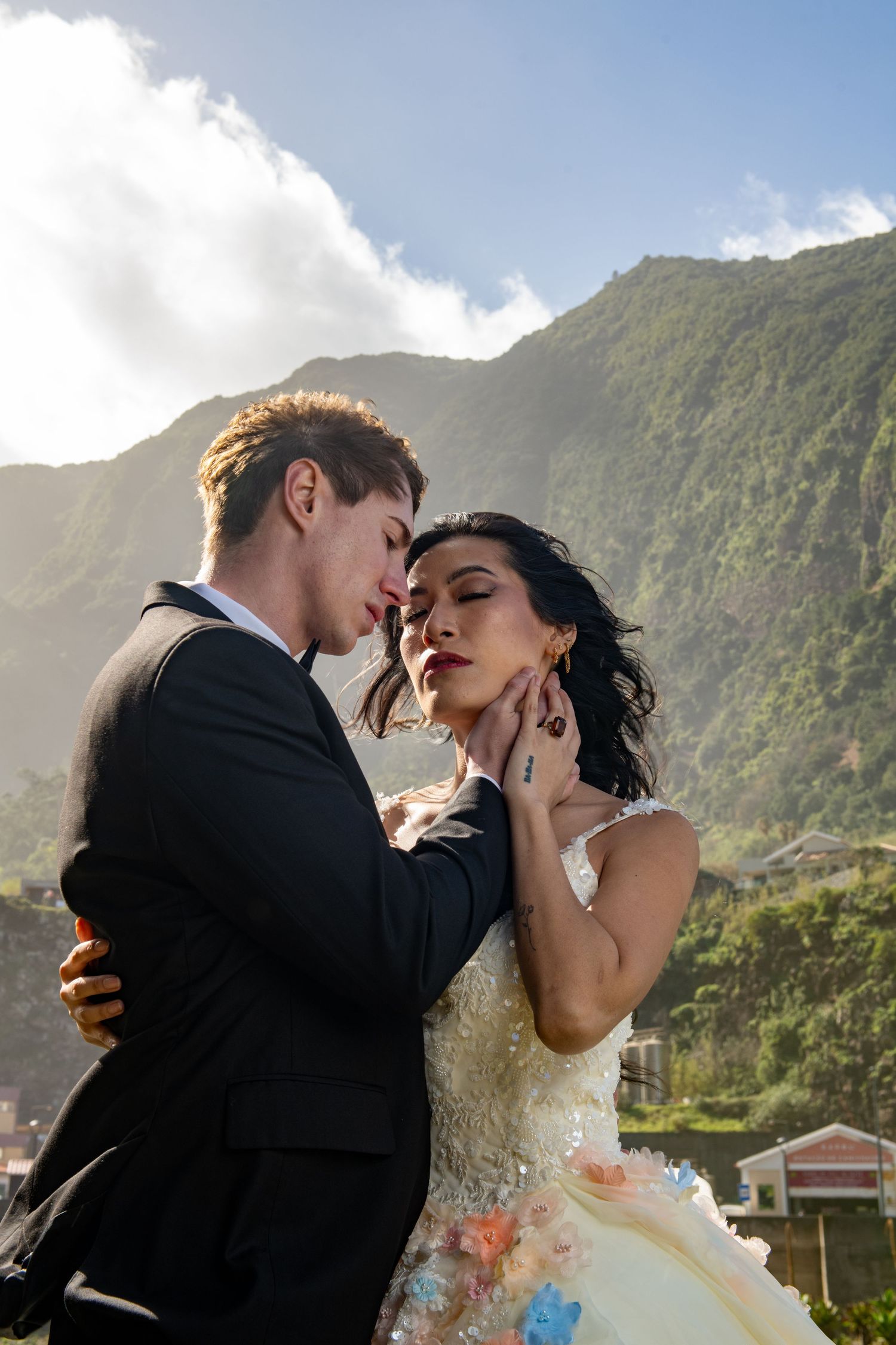 Wedding photography session against a backdrop of majestic mountains and blue skies.