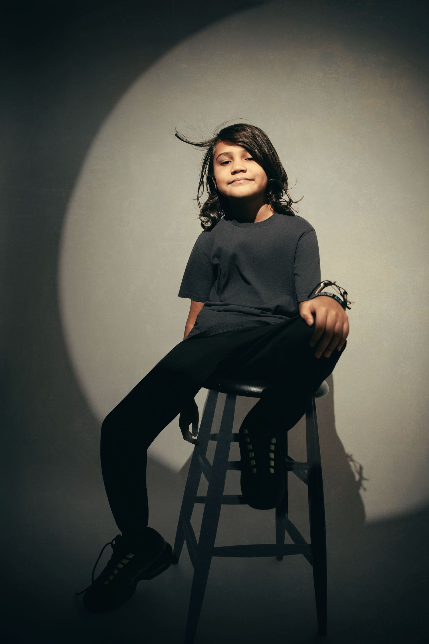 Dramatic portrait series showing seated poses with strong shadow play.