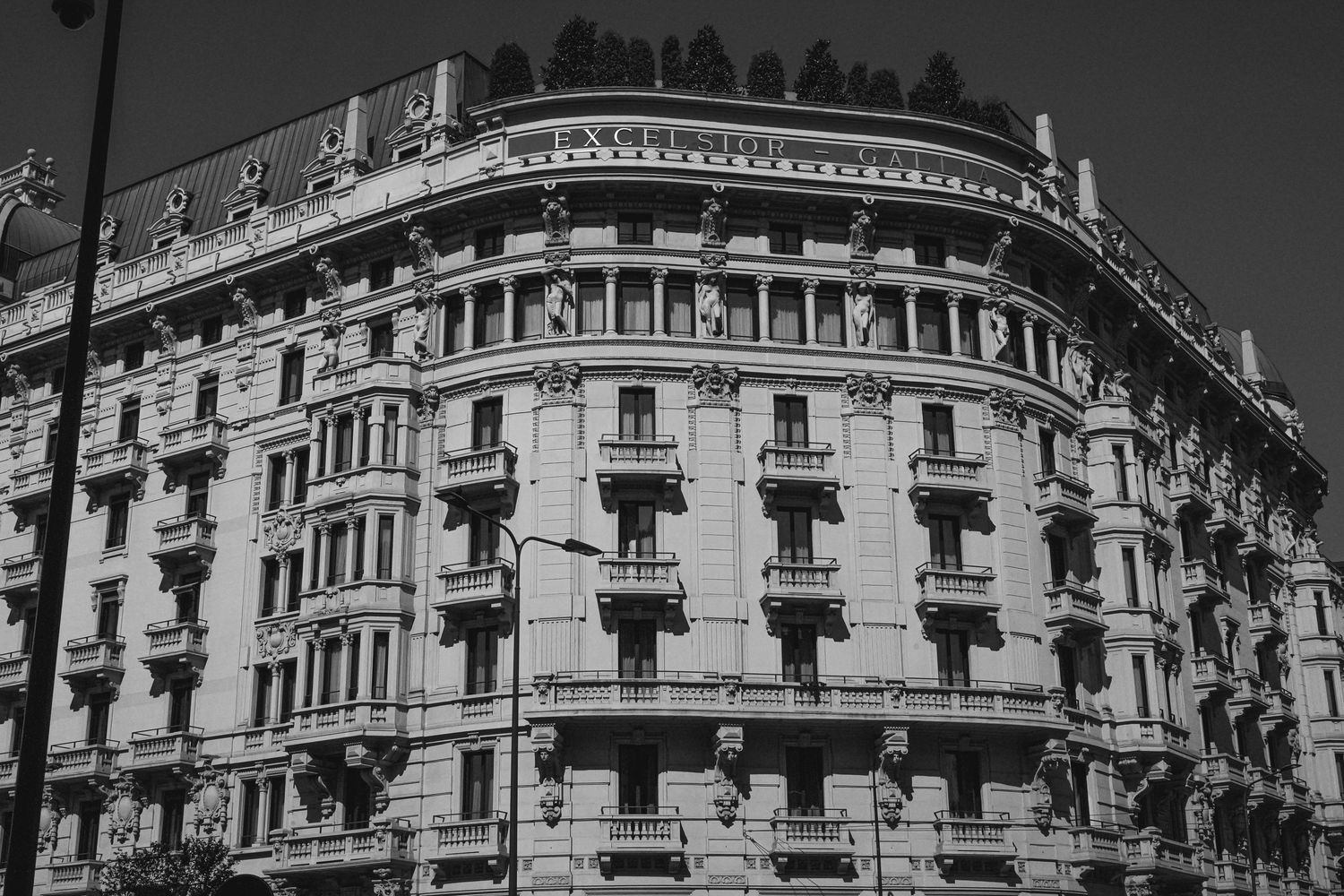 Black and white architectural photo of an ornate European apartment building with decorative balconies.