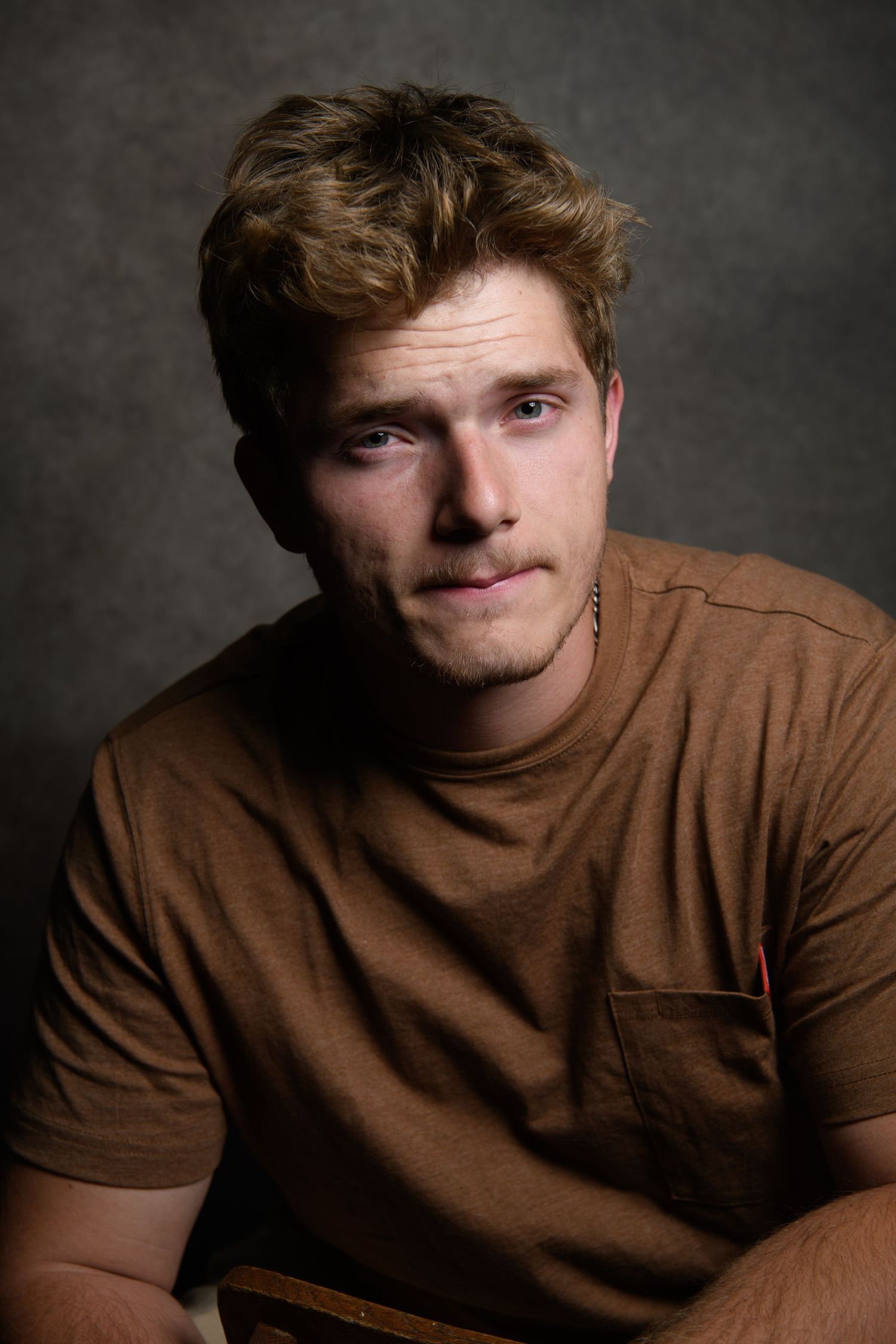 Portrait series showing person in brown shirt with various expressions against dark background.