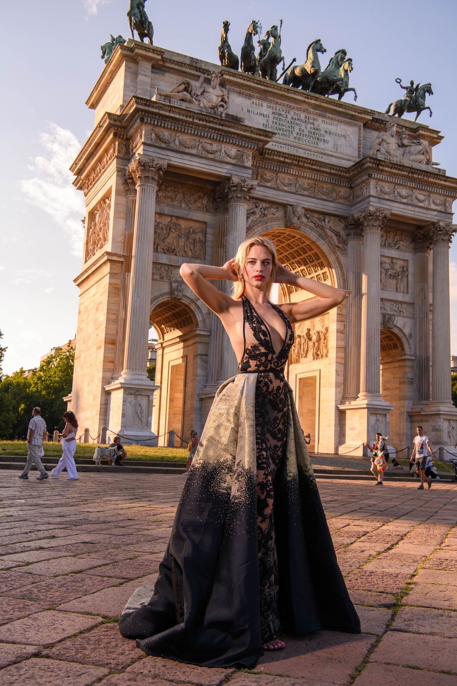 Fashion photography session featuring flowing black gown at monumental archway.