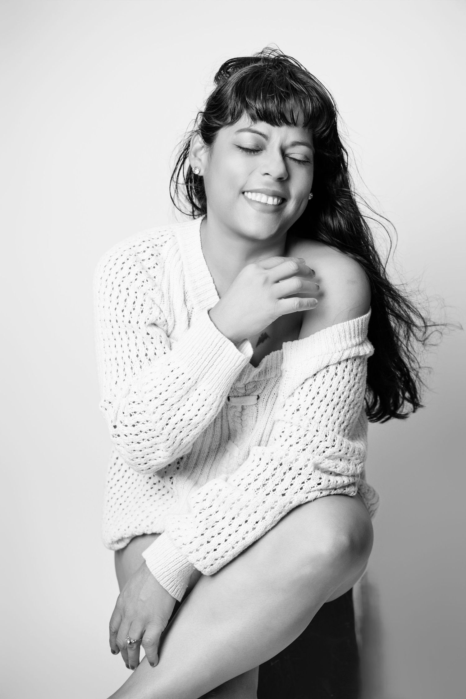 Series of expressive black and white portraits featuring a person in a white knit sweater.