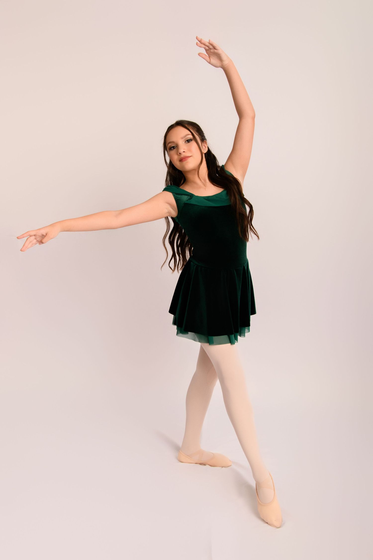 A dancer in a black leotard performs graceful poses against a white studio background.