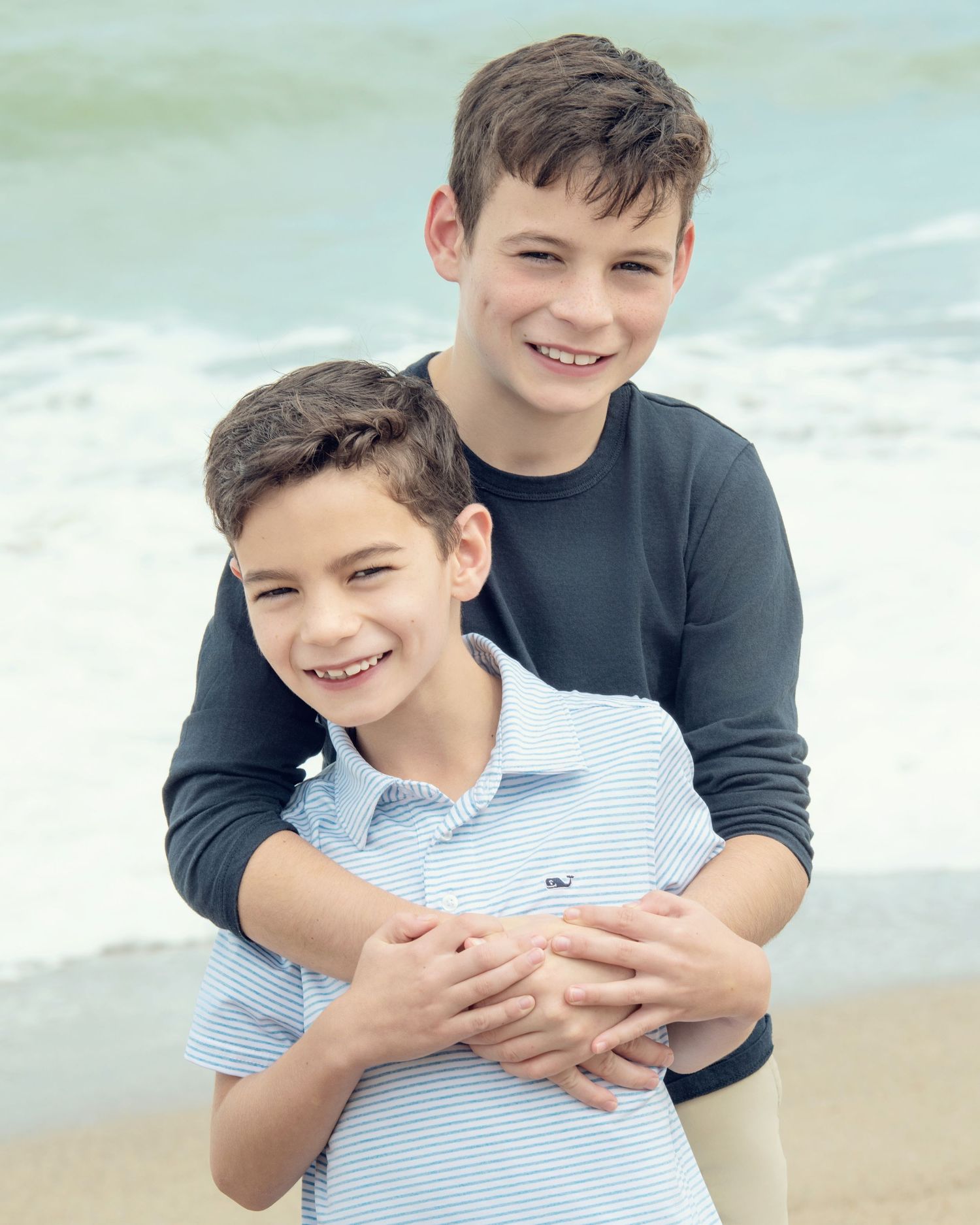 Candid beach portraits showing playful interaction and laughter.