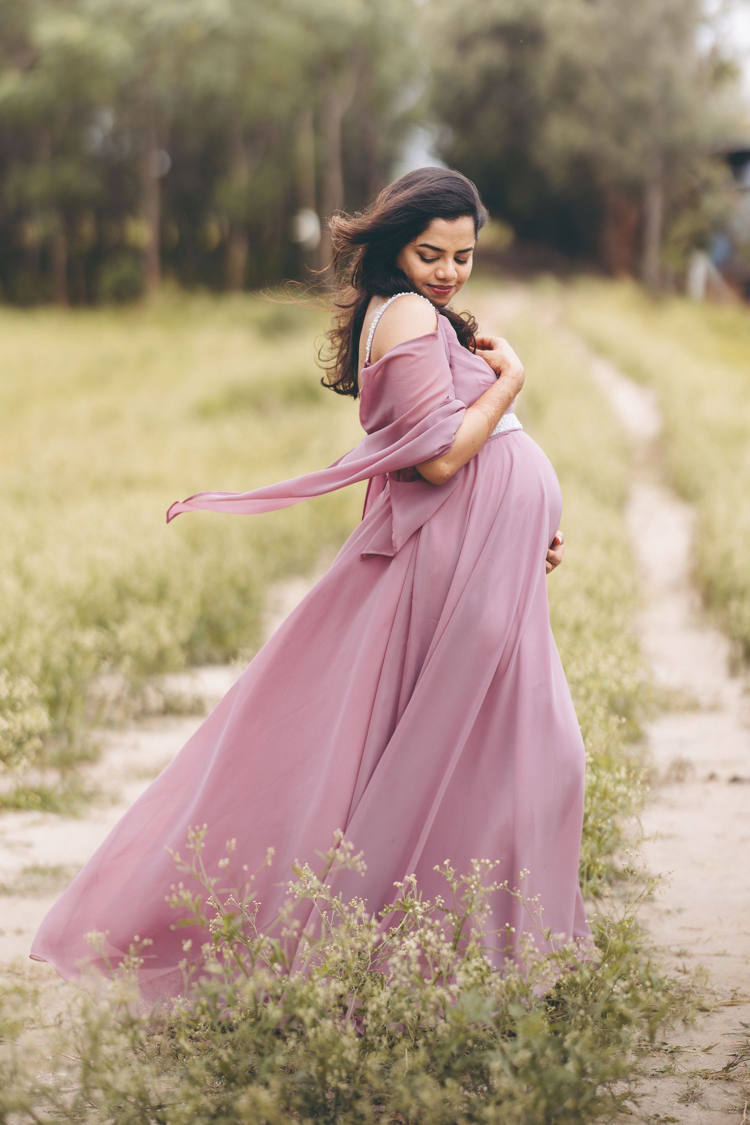 Person in flowing pink dress twirling gracefully in a sunlit meadow.