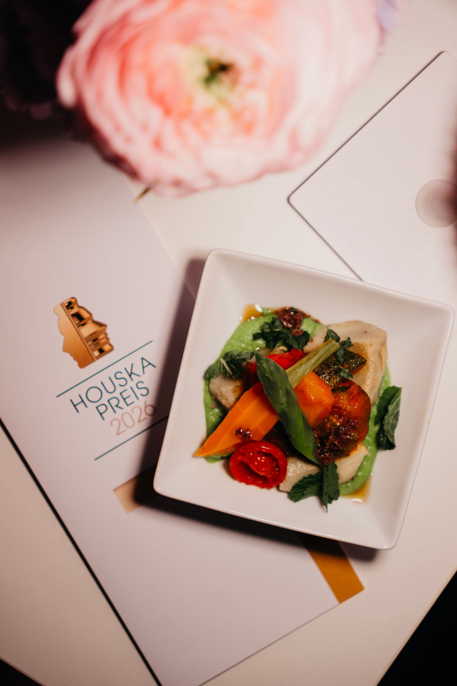 Elegant appetizer plate at Houska Preis 2025 event, featuring colorful vegetables and fish on white square dish.