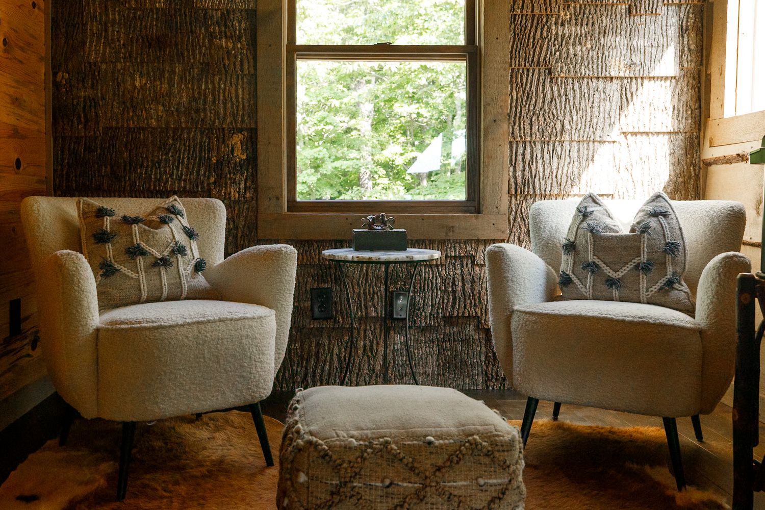Cozy seating area with natural light streaming through windows and textured stone walls.