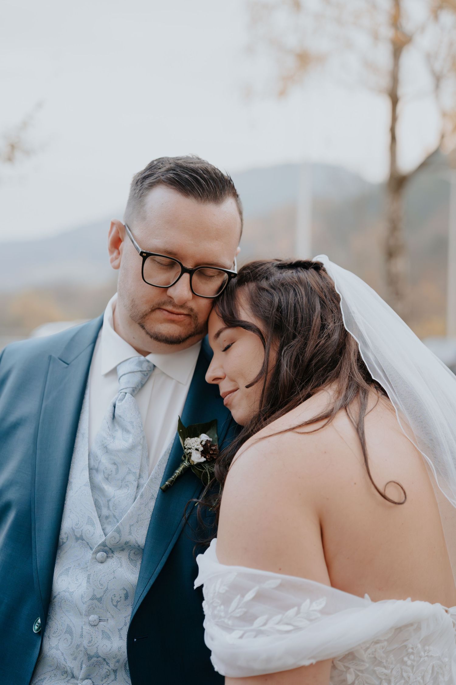 A tender wedding moment captured in soft blue tones.