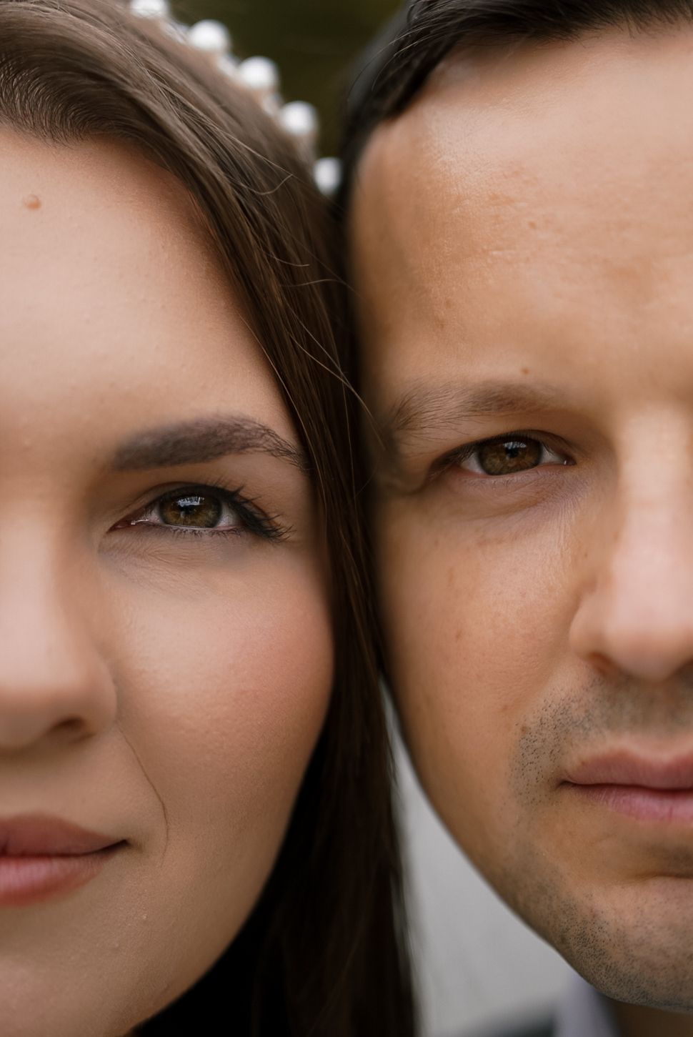 Close-up portrait of a man and woman side by side, both with brown eyes and dark hair, gazing forward.