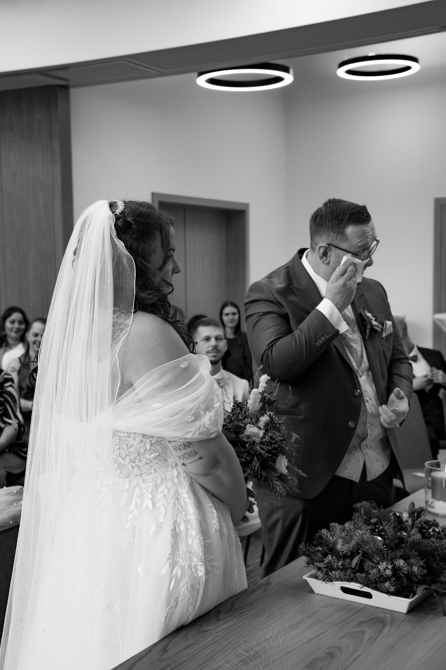 Black and white candid moments from an indoor wedding celebration.