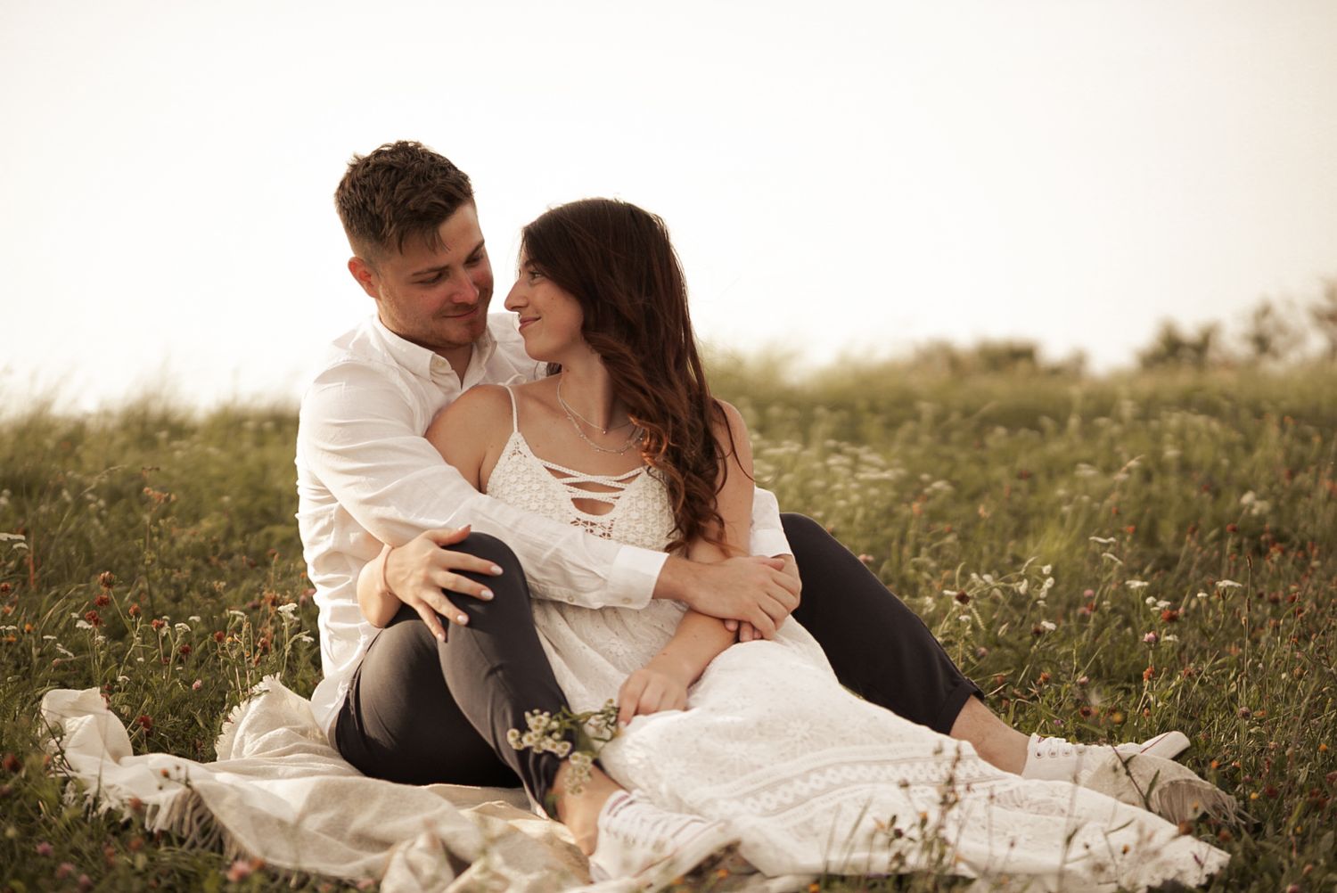 Romantic couple lounging together in a wildflower meadow.