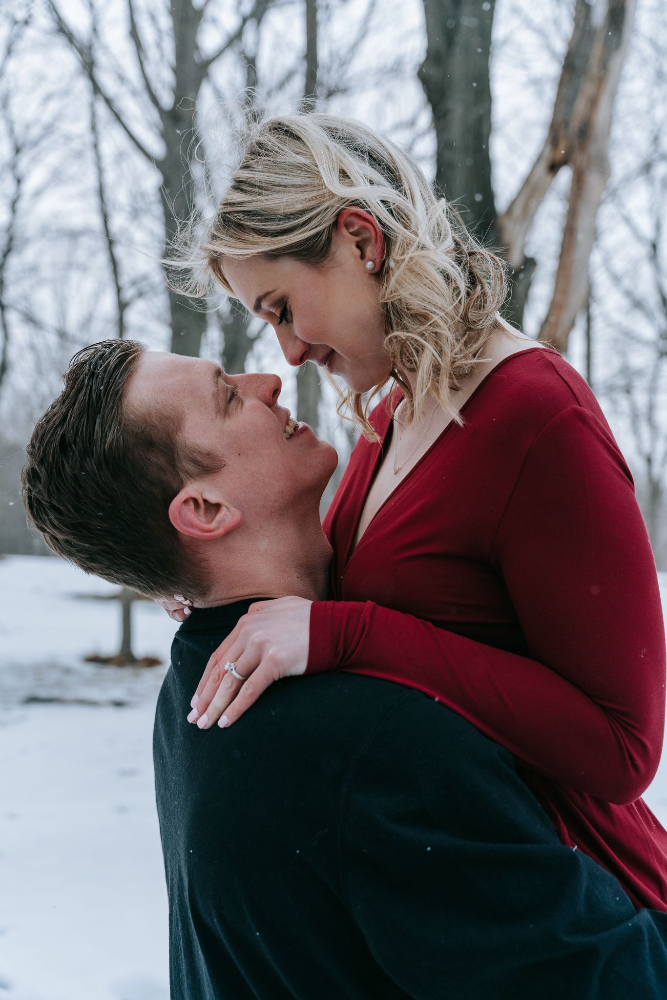 Close-up of engaged couple gazing at each other in snowy winter, intimate moment during candid Rochester NY engagement photography
