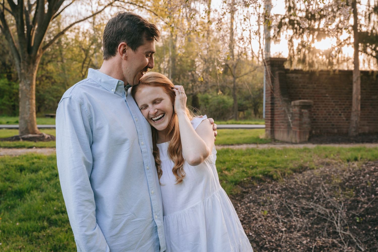 Engaged couple laughing together at golden-hour engagement session in Geneva NY, surrounded by soft evening light in the Finger Lakes