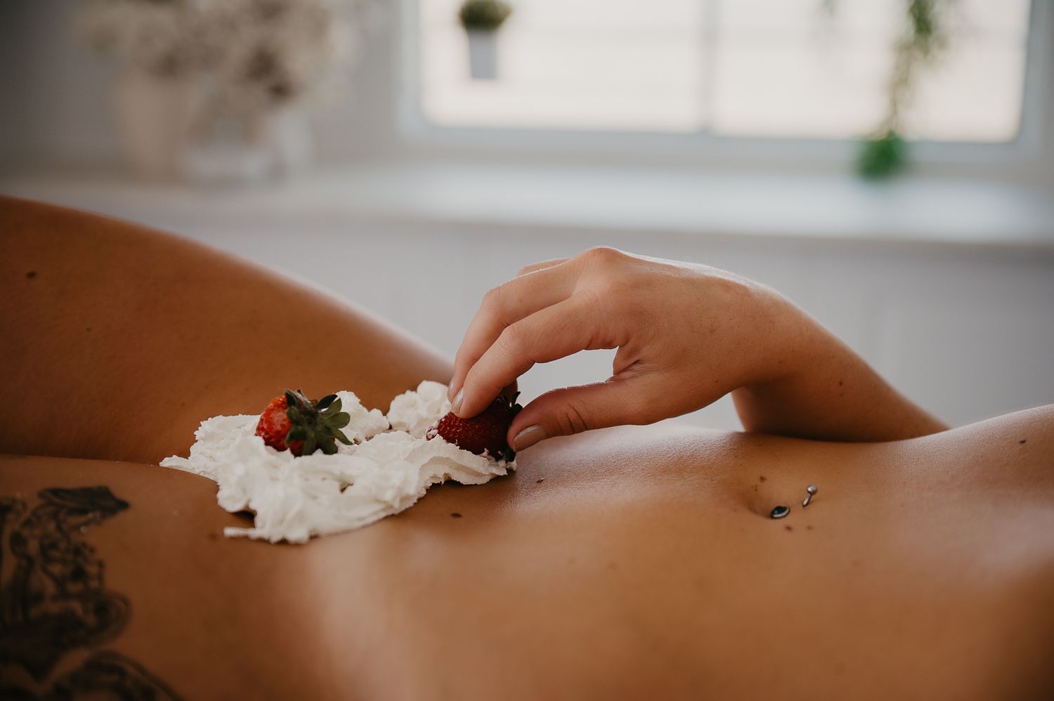 Woman poses for black and white photo with strawberries and whipped cream for boudoir photographer SeduXion Studio in Mandurah WA