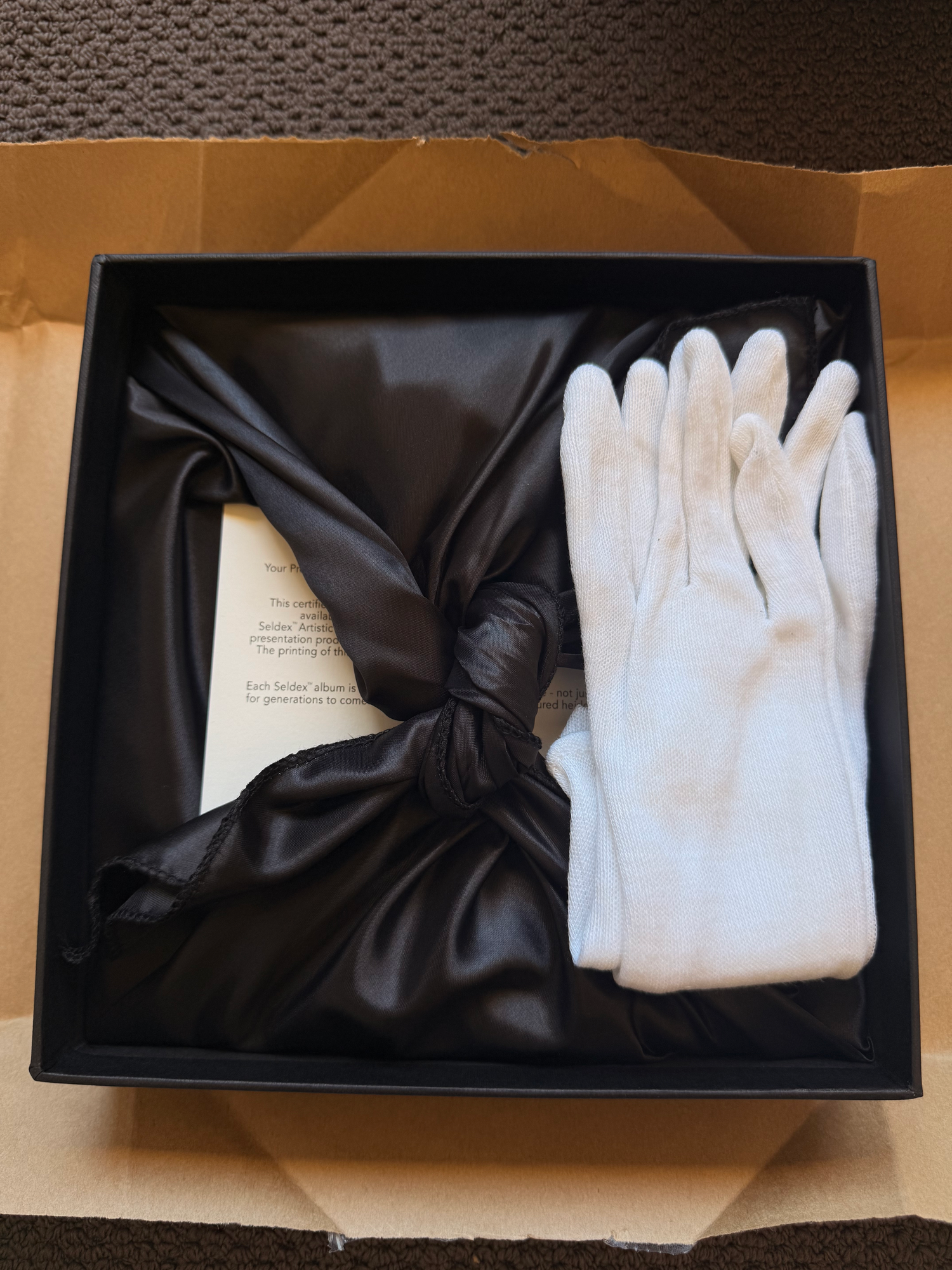A Classic Leather Boudoir Album showing white gloves being packaged in a black presentation box. SeduXion Photographer Bunbury WA