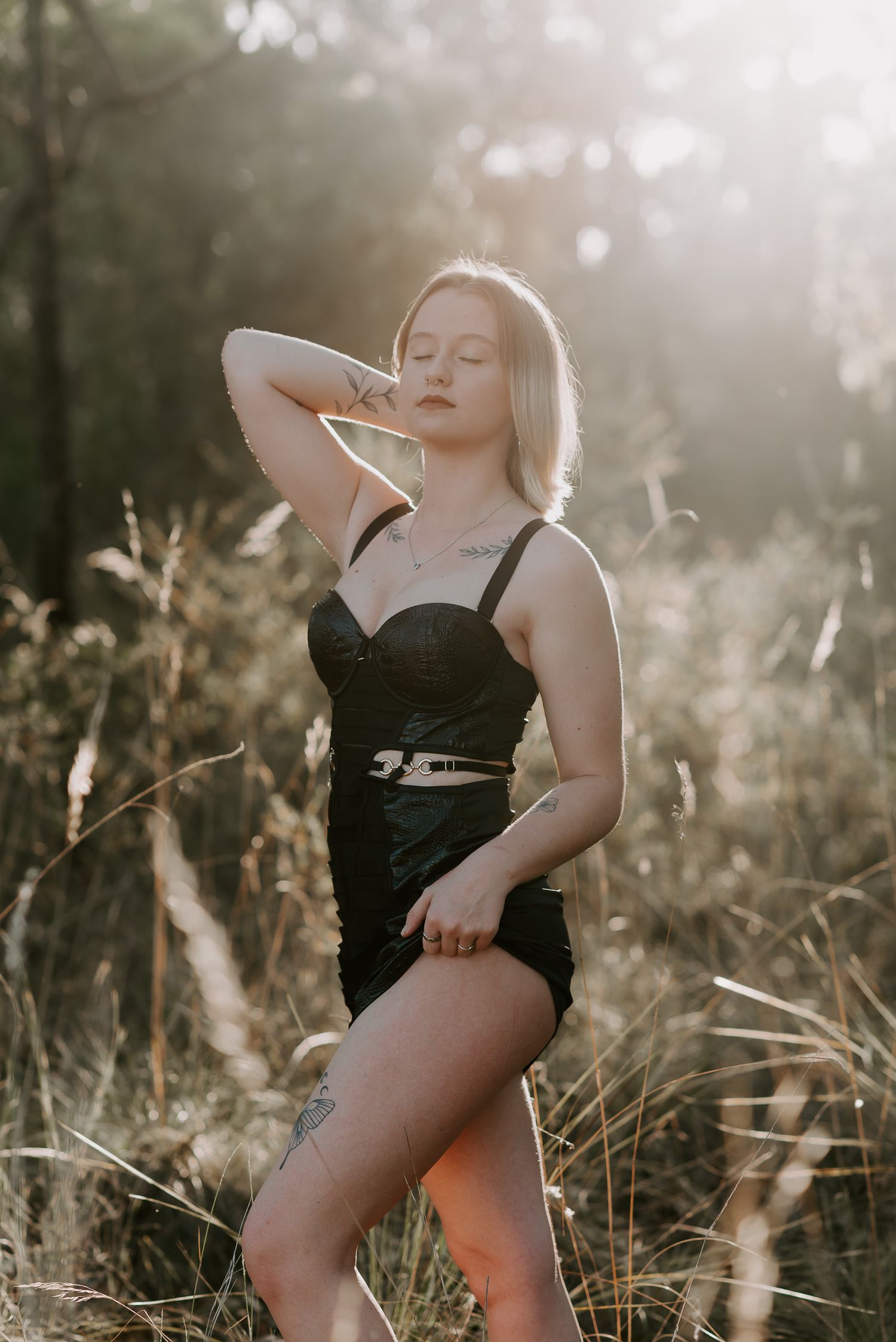 Blonde woman poses in wilderness in black dress for boudoir photoshoot at SeduXion Studio in Mandurah WA