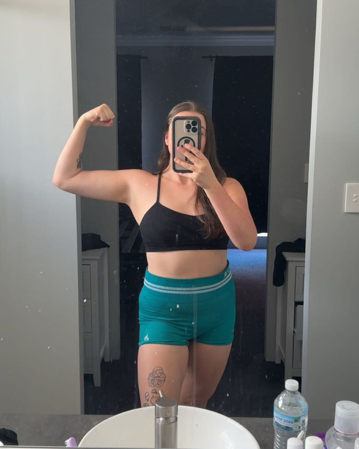 Owner for SeduXion Studio, Paige, poses in fitness outfit for selfie flexing muscles in Mandurah WA