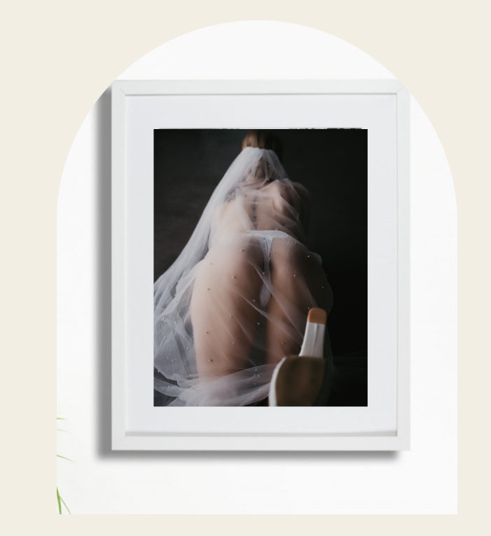Artistic photograph showing a woman draped in a wedding veil against a dark background, for bridal boudoir photographer SeduXion Studio WA
