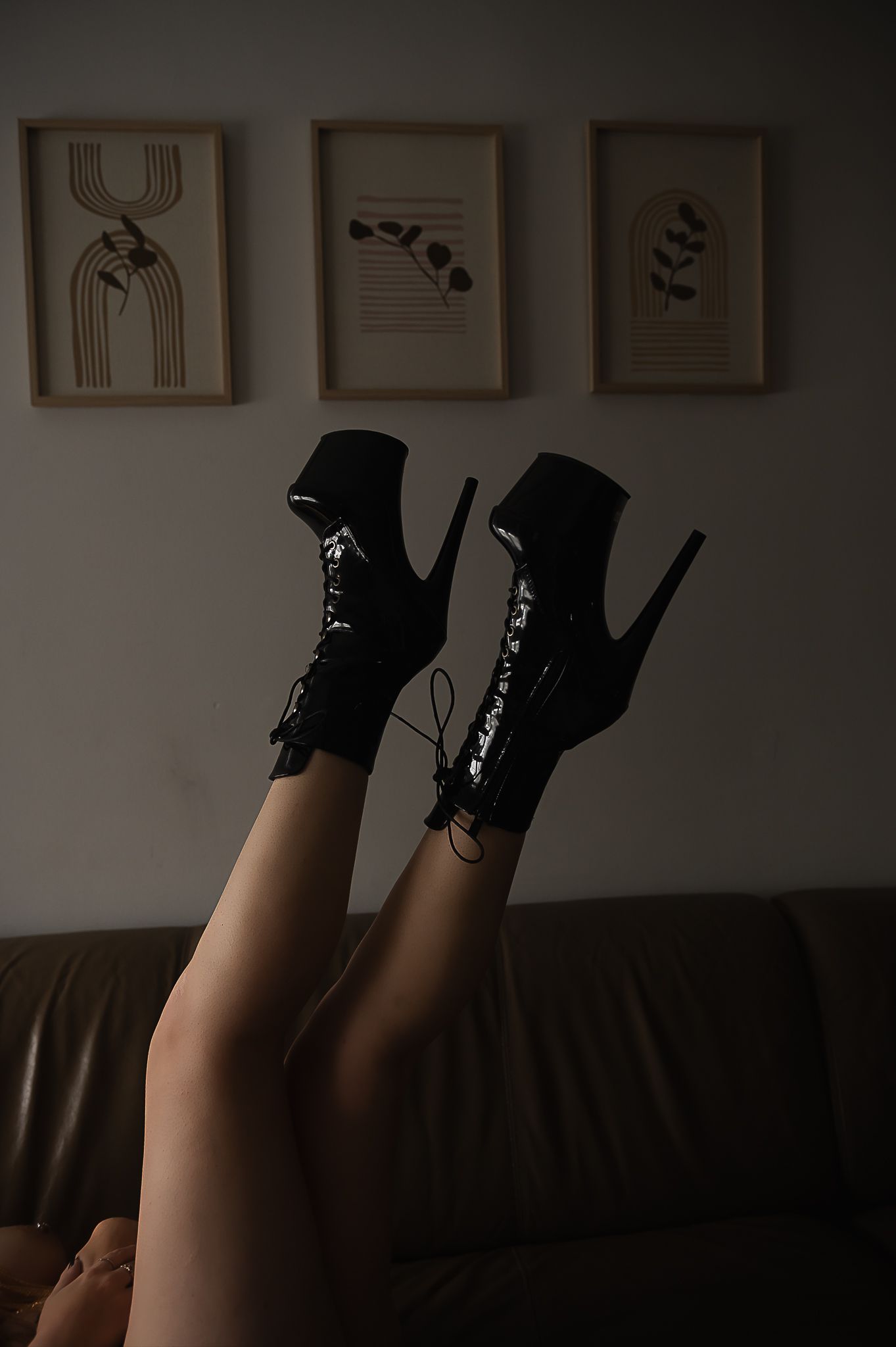 Woman's legs wearing black boots against a dark background for boudoir photoshoot with SeduXion Studio in Mandurah Western Australia