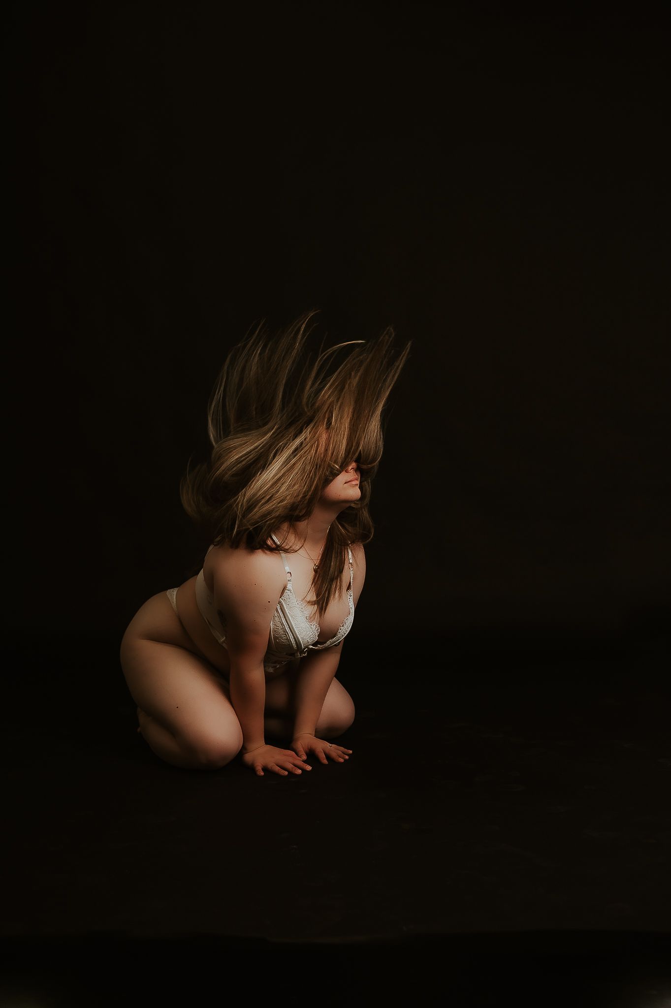 Woman in white lingerie poses flips hair for boudoir photoshoot with SeduXion Studio in Bunbury Western Australia