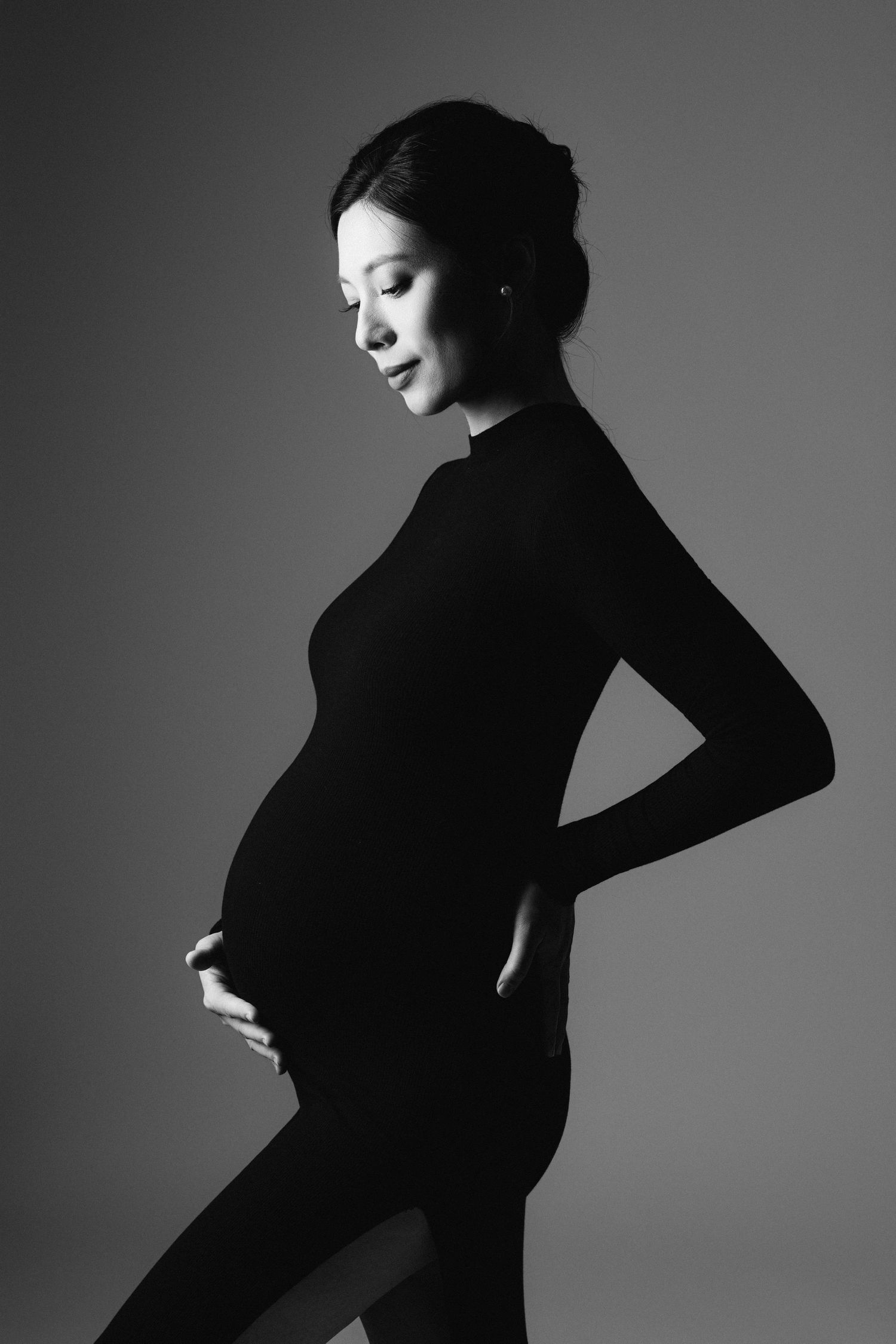 Artistic black and white pregnancy portraits with dramatic lighting.